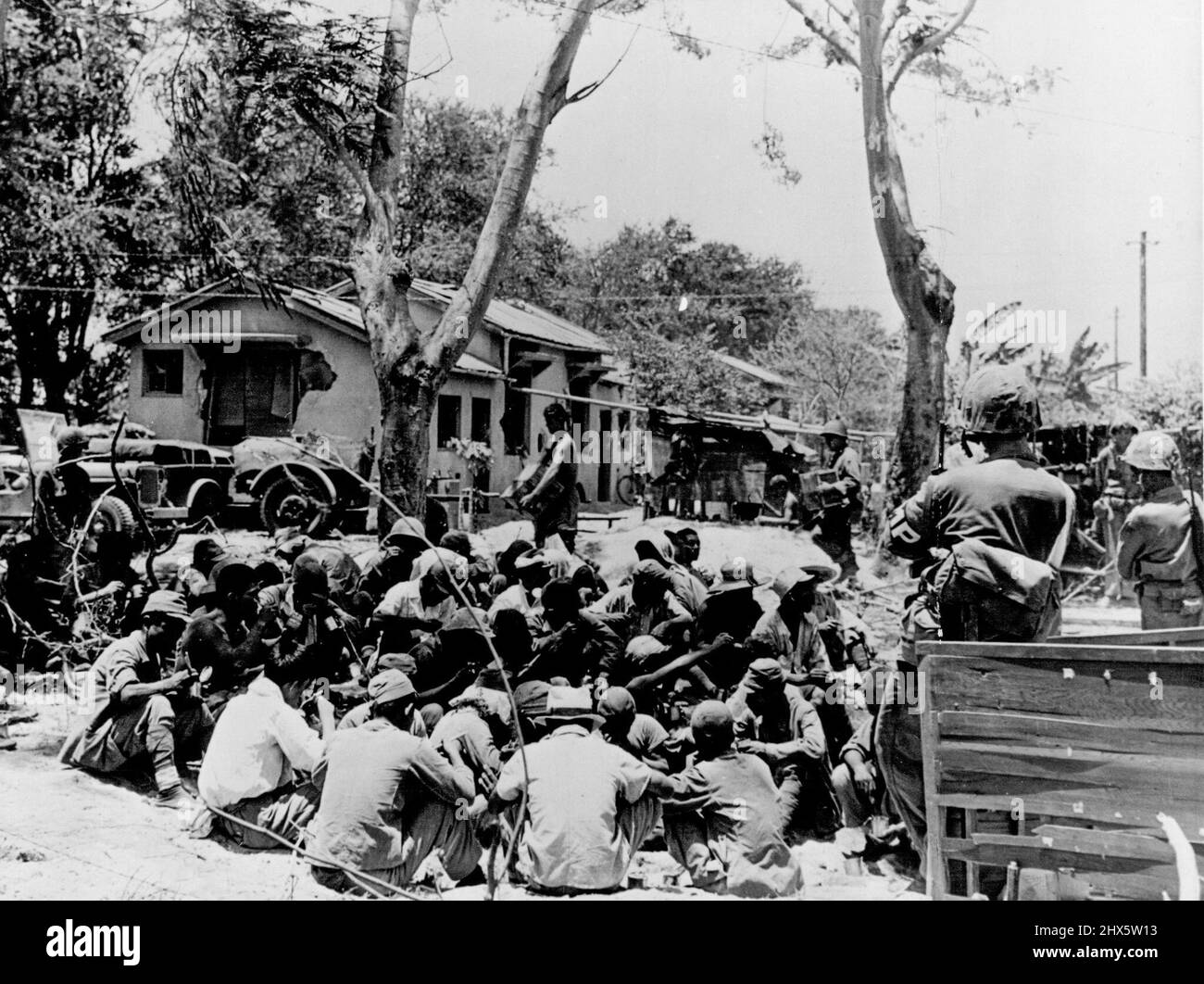 Japanese prisoners huddled together and guarded by Marine forces in Charon-Kanoa, Saipan, a few hours after the invasion began. July 06, 1944. (Photo by U. S. Coast Guard Photo) Stock Photo