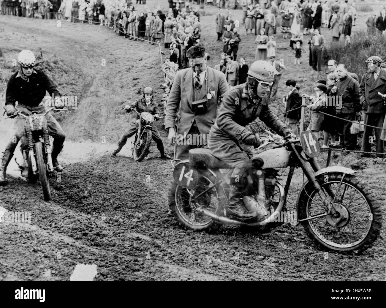 Hobby Riders Test Motorcycles -- Muddy going as Britain's amateur motorcyclist compete in inter-Club scramble. Simulating worst possible motorcycling conditions, with addition of competitive urge of racing, enthusiasts of British motor cycle clubs prove sternest critics of manufacturing quality for machines finding markers all over the world. March 11, 1952. (Photo by Central Office of Information, London). Stock Photo