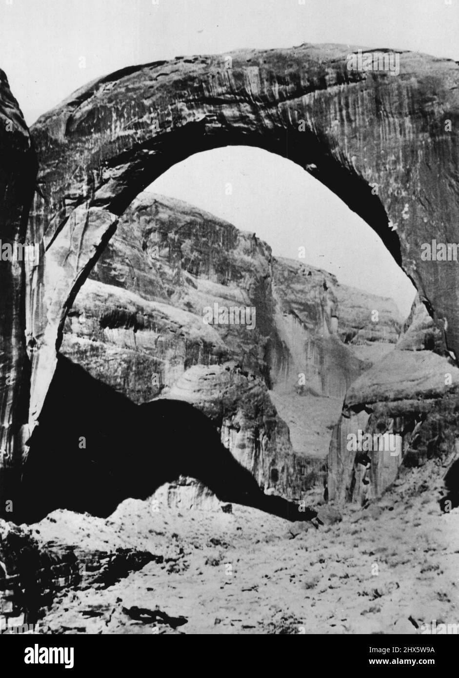 A creature 308 feet high could walk under Utah's Rainbow Bridge, the highest Natural Bridge in the world. Located close to the Arizona Border, it stands amidst rocky Canyons. August 29, 1952. (Photo by United Press). Stock Photo