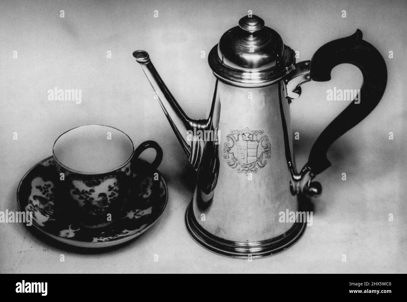 Brought to Australia in 1832 by the Hamersley family one of the earliest pioneering families to settle in Western Australia and whose coat of arms is engraved upon it, this glistening silver coffee pot was made in 1727, during reign of George II. With it is a Georgian cup and saucer. Fashioned by the fine silversmith Edward Vincent, this gracefully elegant example of silver ware bears the London hallmark, the leopard's head crowned and the date letter, a Roman capital 'M,' authenticating the time it was made, which, incidentally, was the same year that Sir Thomas Gainsbor ough was born. The Stock Photo