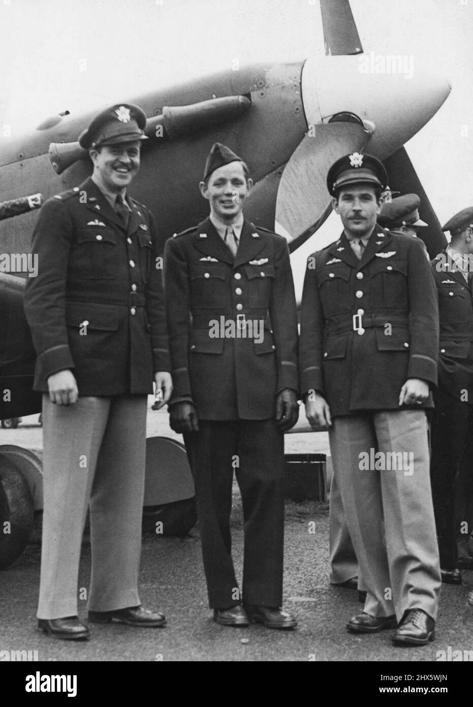 A group of pilots wearing both Air Force wines and U.S. Wings badge in front of a Spitfire.Ceremonial Handing over of Eagle Squadrons R.A.F. today Army air corps at an R.A.F. Station. September 20, 1942. (Photo by London News Agency Photos). Stock Photo