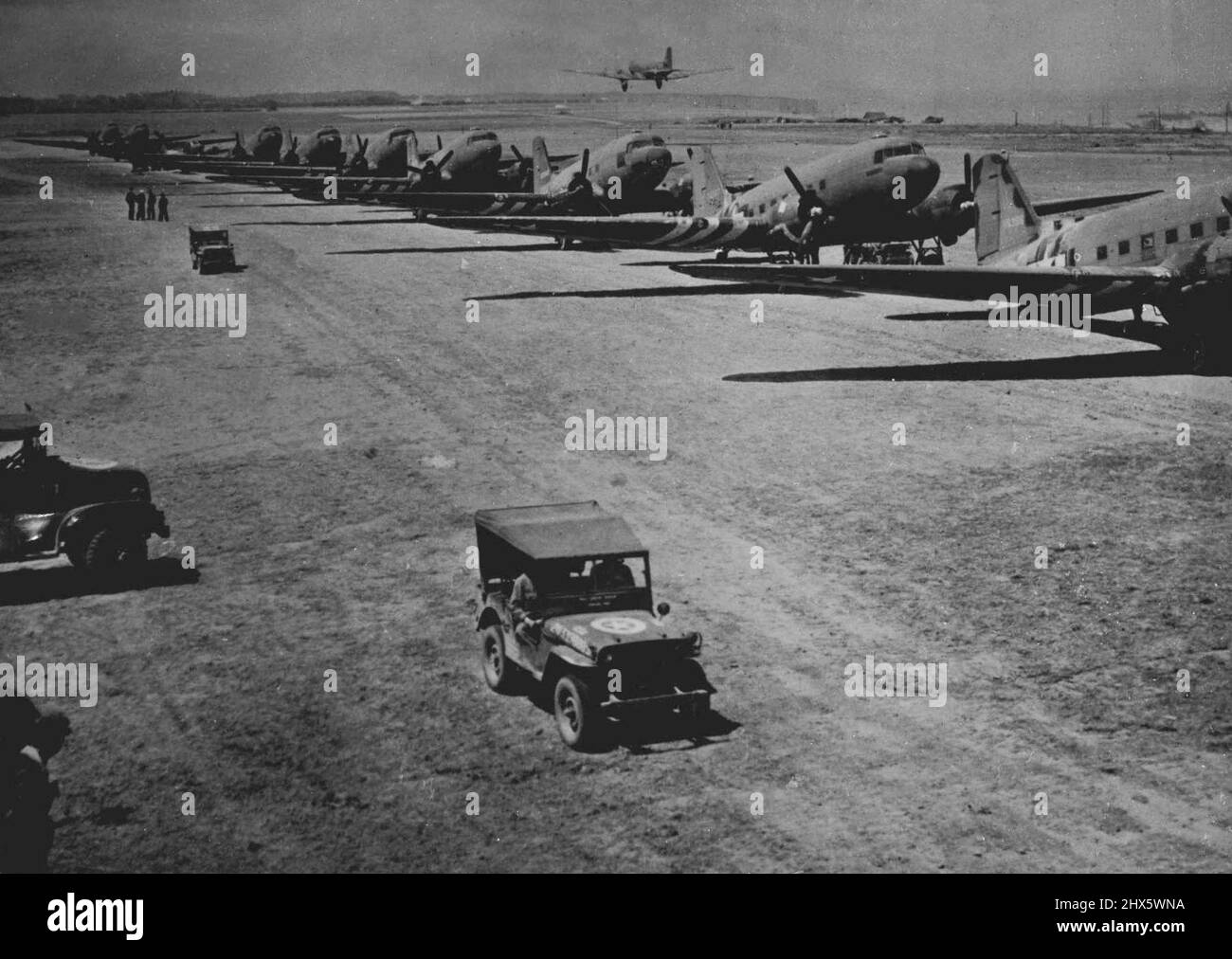 American Aircraft Line Up At French Field -- An American transport plane takes off in the background over a long line of aircraft at an airfield somewhere in Normandy. Air transport plays an important part in the supplying of growing Allied armies in France. By July 21, 1944, there were enough American-built airfields in Normandy to handle more than 1,000 fights daily. In addition, many airfields have been abandoned by the Germans in their retreat before allied forces. August 21, 1944. (Photo by Stock Photo