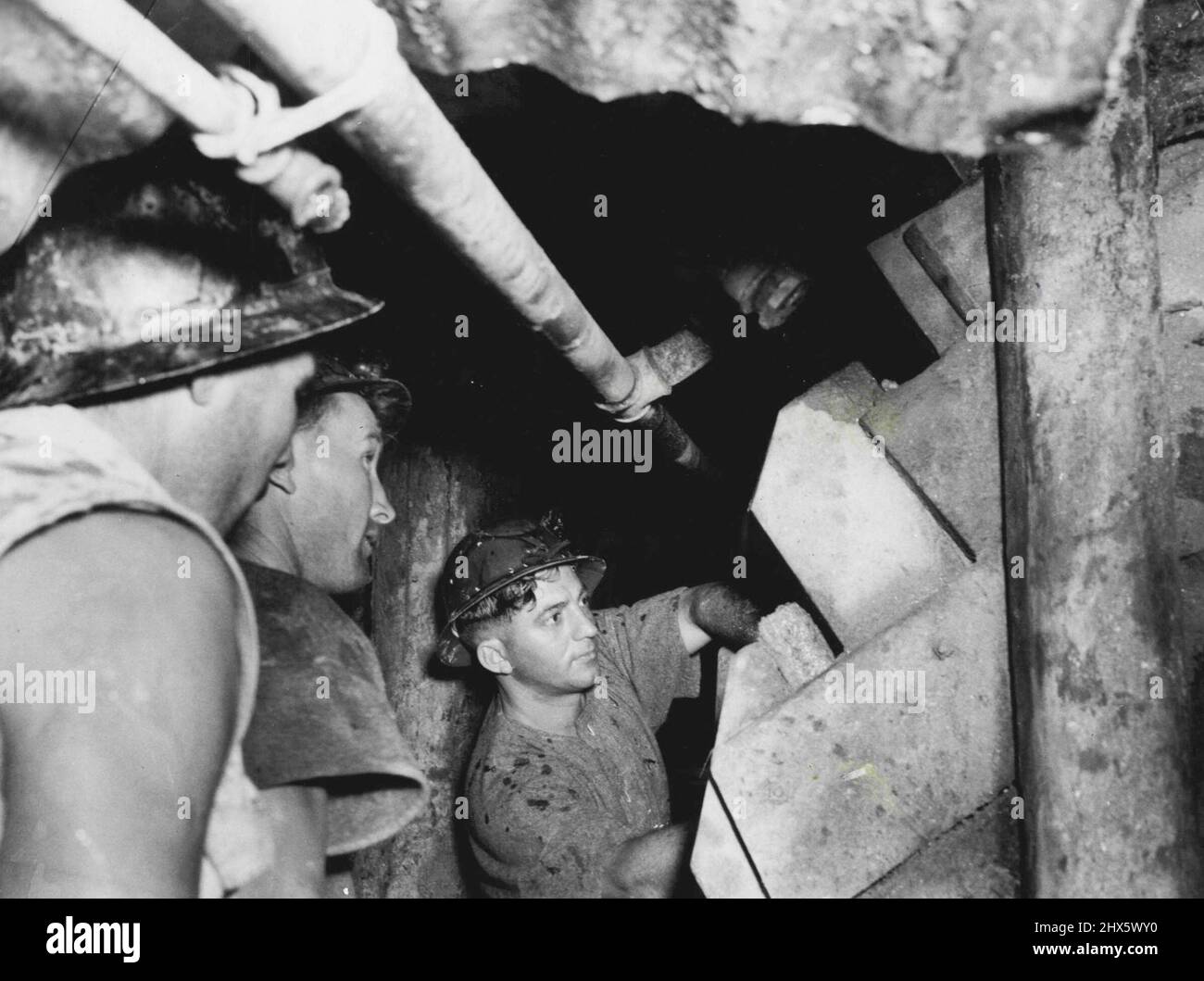 Three miners work in a level below the two men who were entombed by a ...
