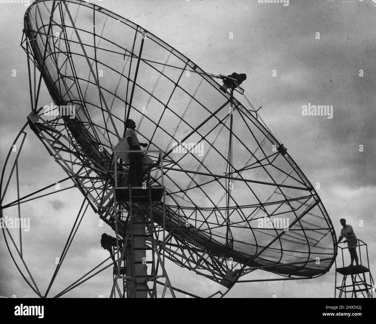 Workmen making final adjustments to the giant radio telescope at the