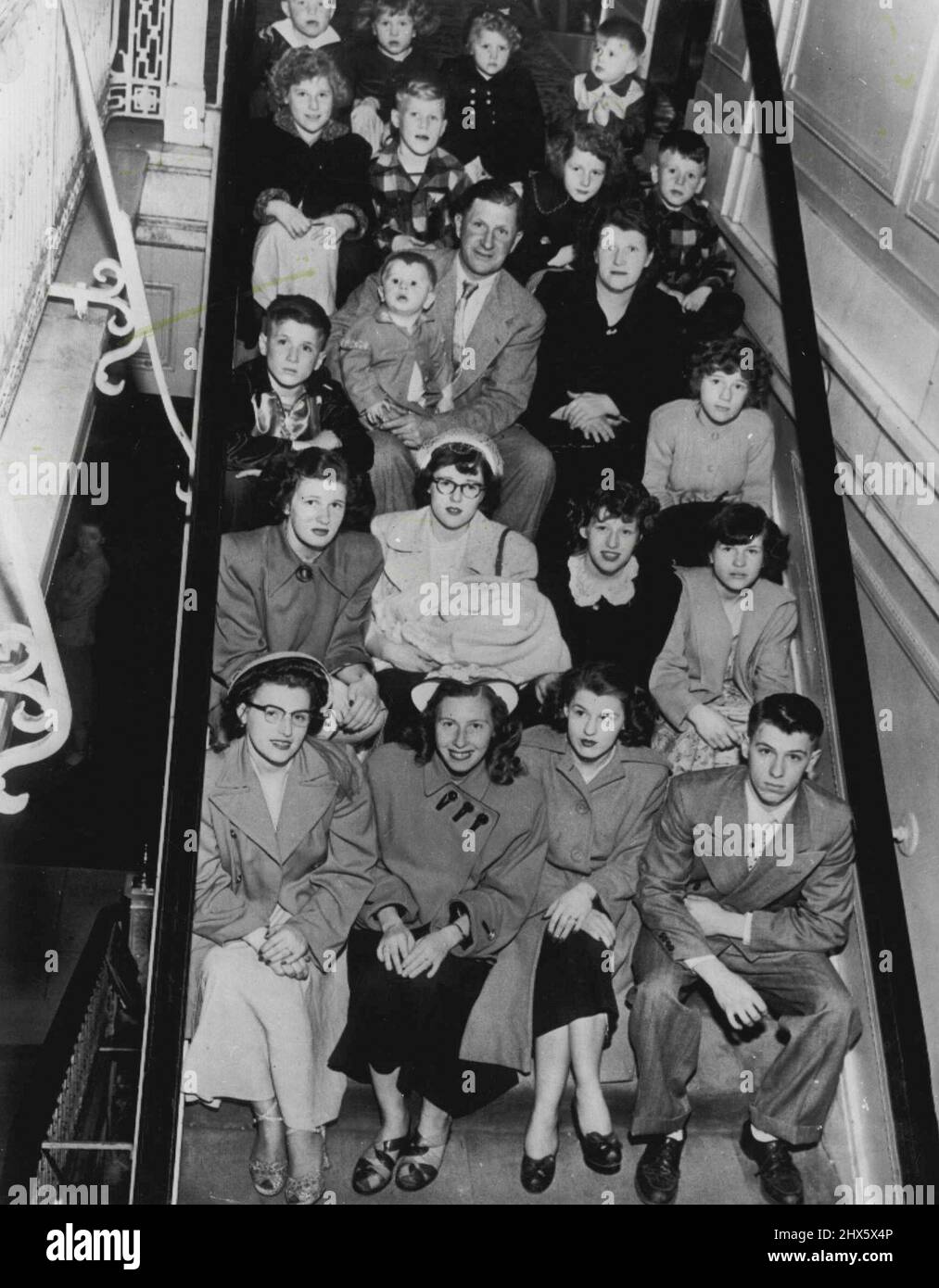 They Certainly Know The Score - And More - Here is a family 22 which happens to be one-thirty-seventh of the population of Soldiers Grove, Wisconsin 50 miles southeast of LaCrosse. Picture was made at Morrison hotel here as family came to Chicago for an outing. Here they are: Front row (l. to r.) Mrs. Marjorie ***** Mrs., Lola Underwood, Mrs. Betty Burnett and Marlin Schoville; second row, Mrs. Phyllis Benson, Donna Schoville (holding Stephen, one month old), Annabelle and ***** Schoville; third Stock Photo