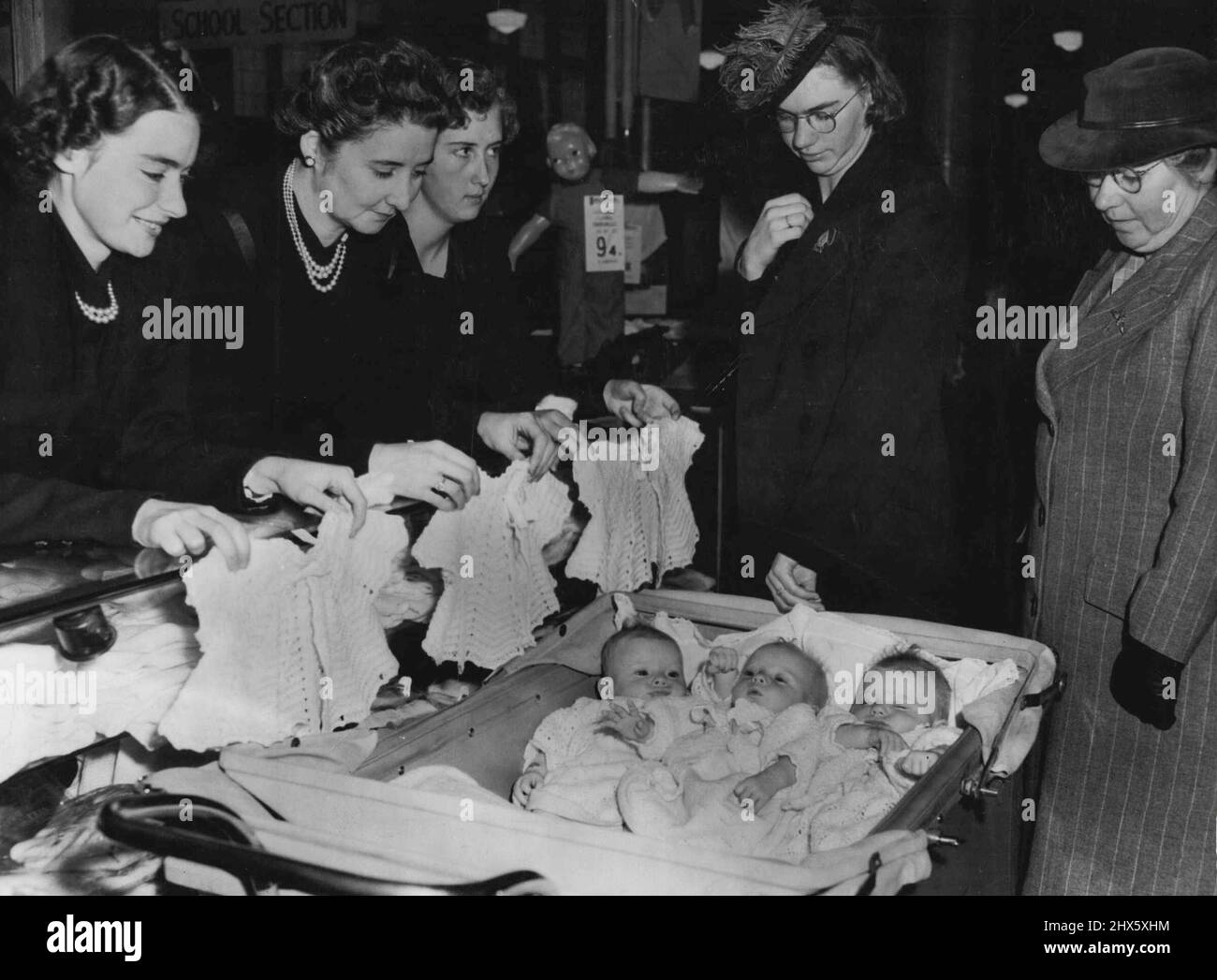 Triplets Go Shopping. Work stopped and shoppers gathered around when Mrs. William Edgar, of Preston (Vic.), took her three-months-old triplets Margaret, Janice and Anne to do some stopping. In their specially-built pram, the triplets mere given plenty of service. March 20, 1947. Stock Photo