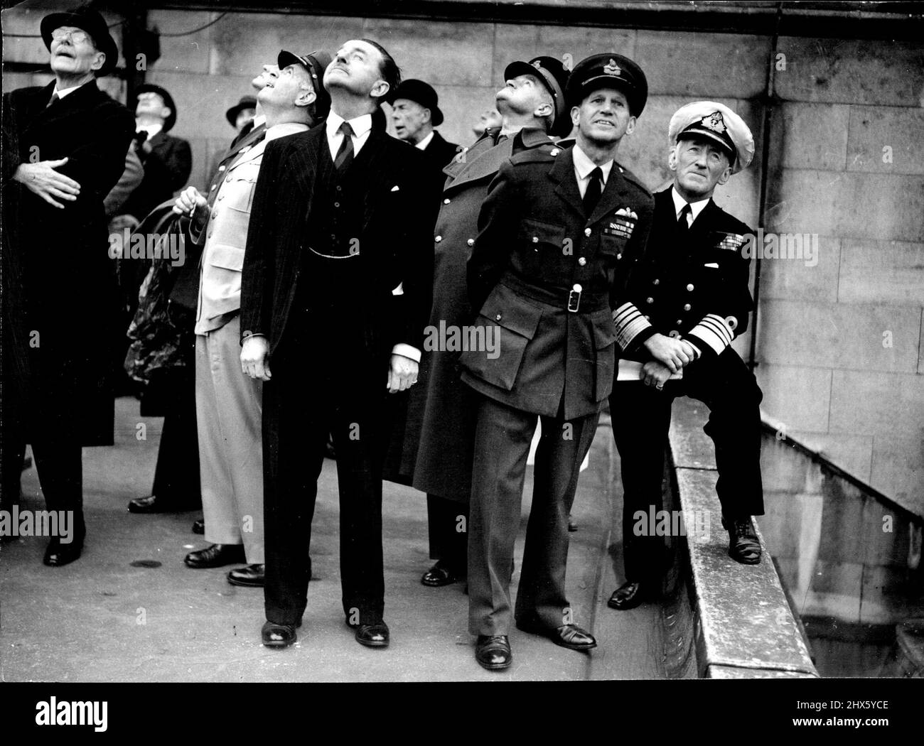 Battle Of Britain Fly Past -- Defence Chiefs watching the fly-past from the roof of the new government offices in whitehall. Left to right are: General Francis H. Griswold, United States Air force; Earl Alexander of Tunis, the minister of Defence; Field Marshal Sir William Slim; Air Chief Marshal Sir John W. Baker, Deputy of Air Staff; and Admiral Sir Rhoderick R. McGrigor, first sea Lord. 213 Aircraft took part in to-day's fly past over London in commemoration of the Twelfth anniversary of the Stock Photo