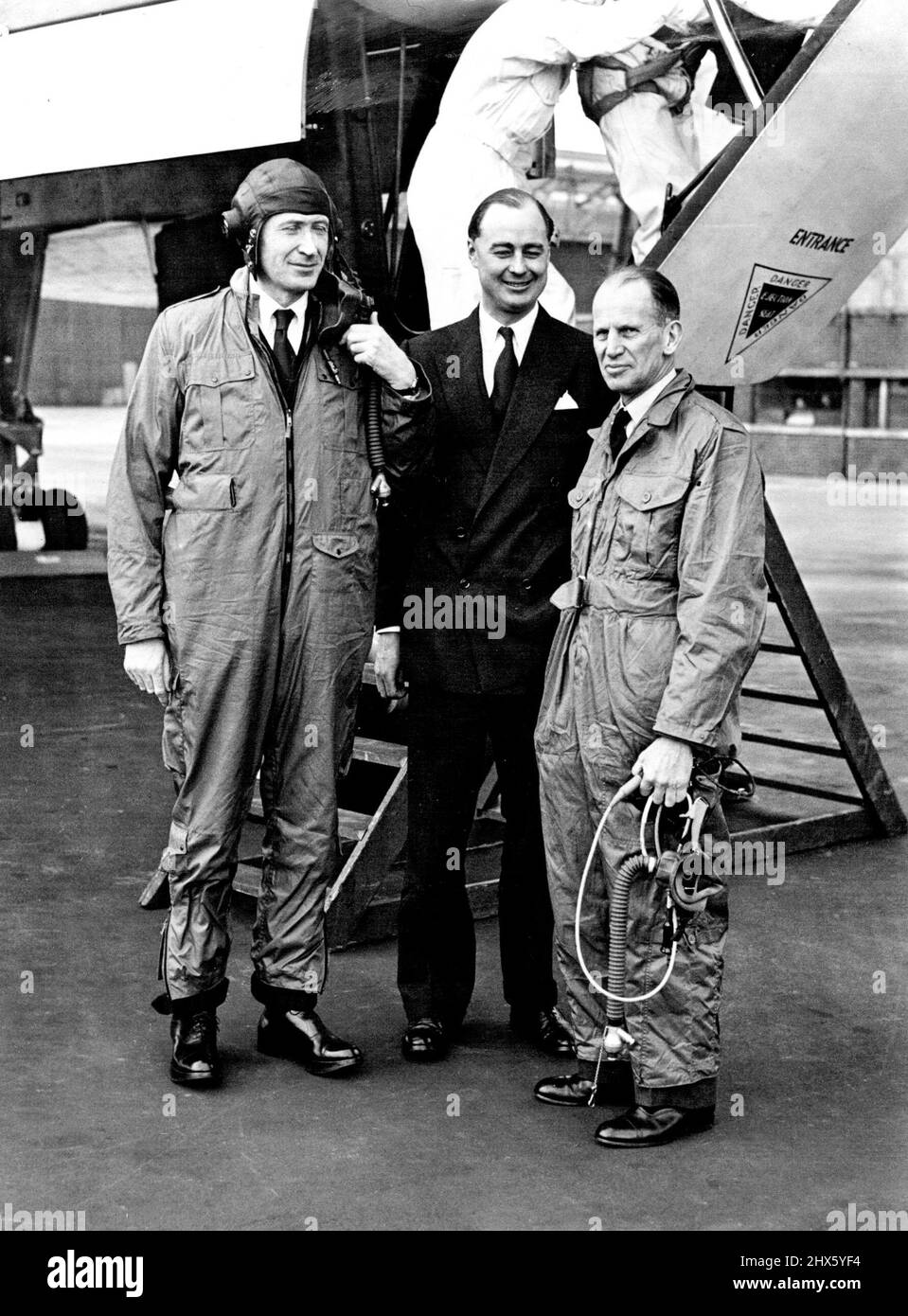 Minister Tries Out Vulcan Jet Bomber -- The Minister of Supply, Mr. Duncan Sandys (left) is pictured here with Avro's Superintendent of Flying, Wing Commander Roland Falk (Centre) and Air Chief Marshal Sir John W. Baker at Woodford Airport, near Manchester, today (Saturday) after a flight in one of Britain's latest jet bombers, the Delta-wing Avro Vulcan. The Minister took over the flight, over the Isle of Wight and back by way of Holyhead, In which the plane is believed to have reached more tha Stock Photo