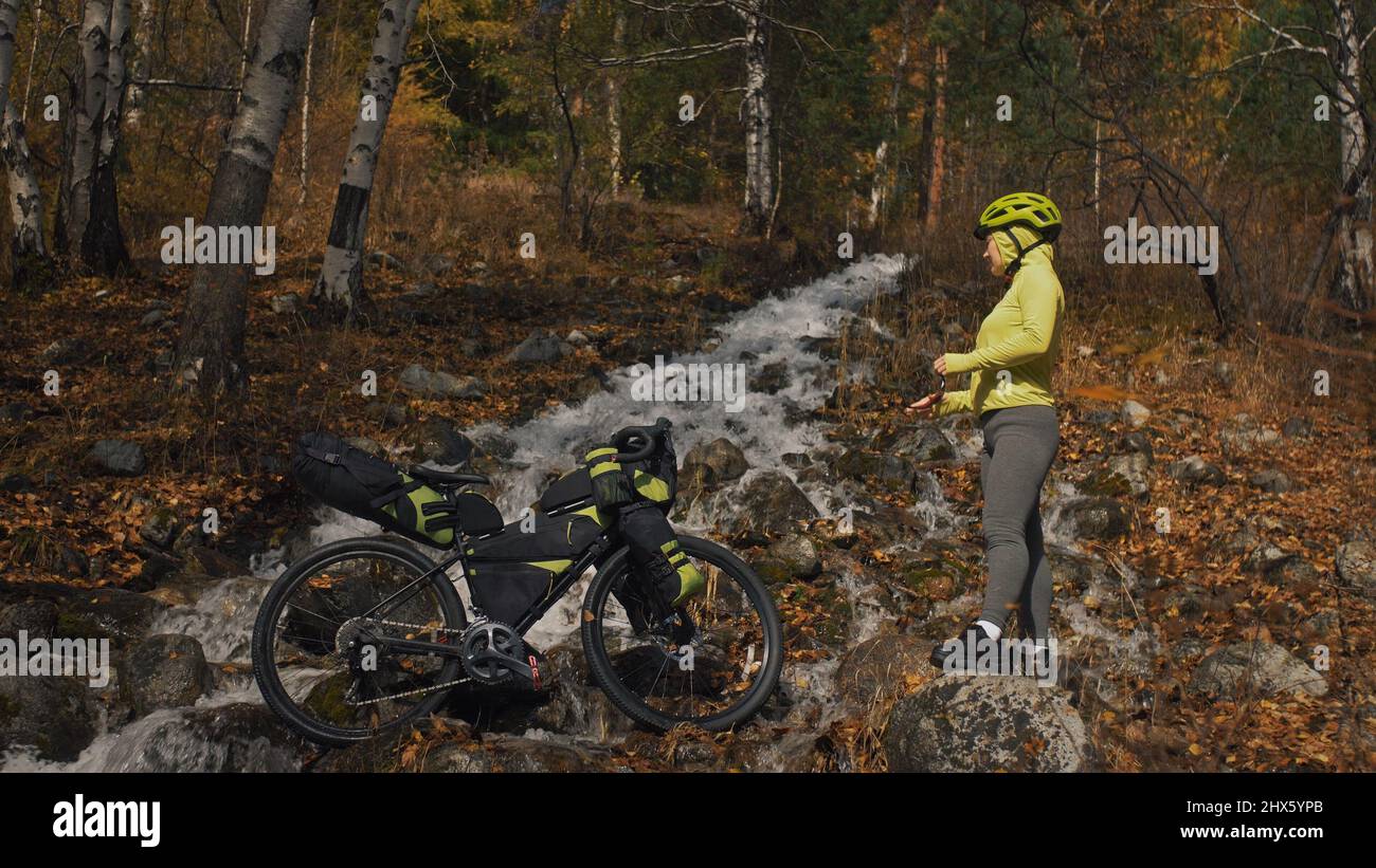 The woman travel on mixed terrain cycle touring with bikepacking. The