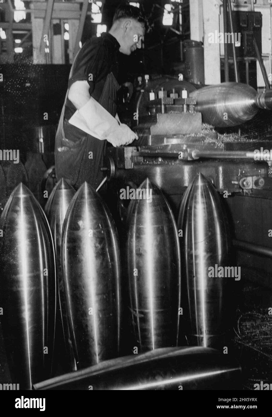 Armor-Piercing Bombs are now in full production at a Government ordnance factory somewhere in Australia. Here is a picture taken in a section of the factory where the 250-pounders are finished off on a lathe. February 22, 1943.;Armor-Piercing Bombs are now in full production at a Government ordnance factory somewhere in Australia. Here is a picture taken in a section of the factory where the 250-pounders are finished off on a lathe. Stock Photo