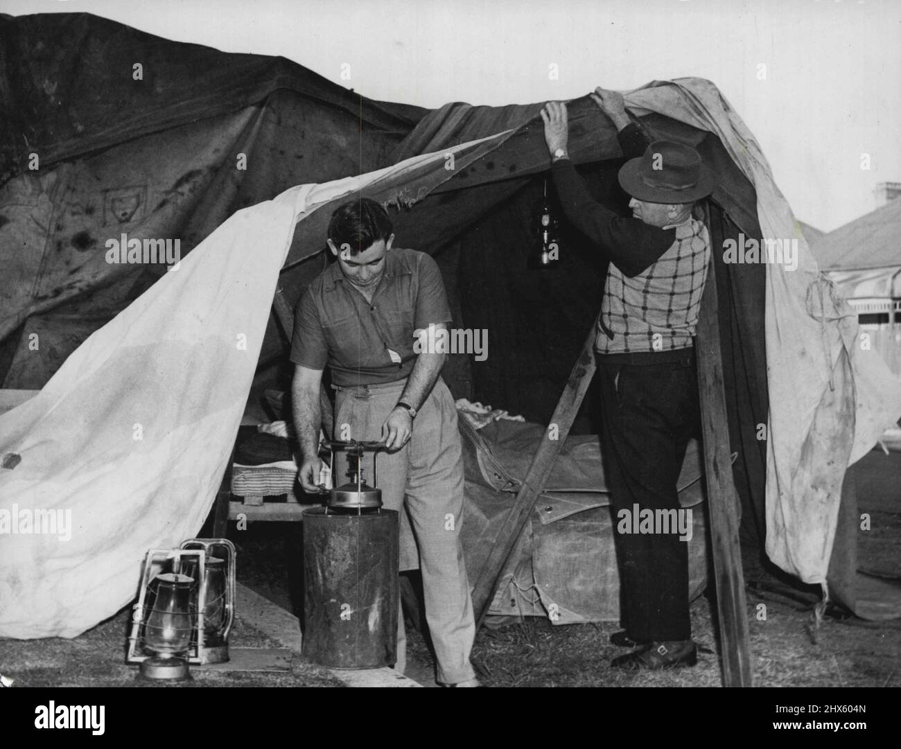 Eviction after 19 yrs Tenancy. Who (left to right): 22 yr old Mr Neville Buckley (Junior) & his father Mr C.Buckley. Where: Haroy St Mascot. When: 7 am. Why: About to prepared breakfast in the tent on the footpath which also covered their furniture & belongings. April 6, 1949. (Photo by Hood).;Eviction after 19 yrs Tenancy. Who (left to right): 22 yr old Mr Neville Buckley (Junior) & his father Mr C.Buckley. Where: Haroy St Mascot. When: 7 am. Why: About to prepared breakfast in the tent on the Stock Photo