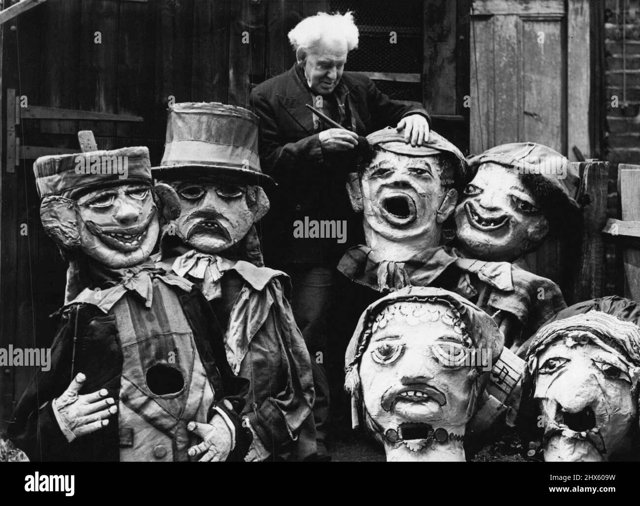 81-Year-old Barnum And Bailey Clown Still Makes Them Laugh -- 81-year-old Harry Russell photographed at work among some of his grotesque giant heads which he makes. In a white-washed shed in Norwood High Street, West Norwood, a youthful old man with a bushy mop of white hair continues a long life of making people laugh. 81-year-old Mr. Harry Russell was once a famous clown with Barnum and Bailey's circus, an claims to be its oldest survivor. He now spends his days making the giant papier mache Stock Photo