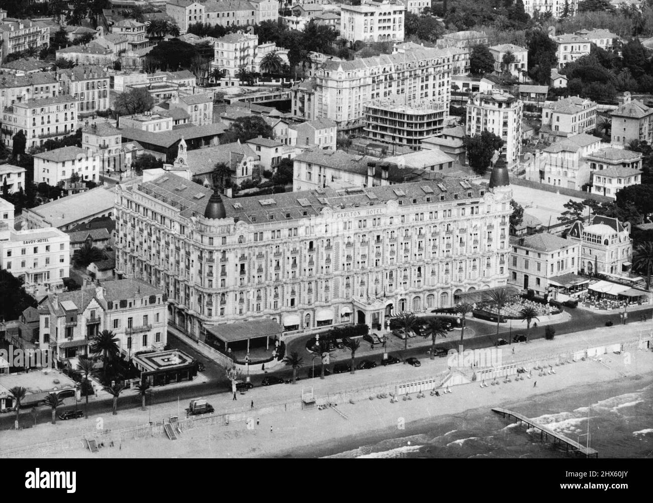 Prince Takes Over Hotel For Rita's Wedding : A new aerial view, taken this week, of Cannes, showing the Carlton hotel. The huge Carlton hotel, on the front at Cannes has practically been taken over by Prince Aly Khan for the reception after his wedding to Rita Hayworth at Vallauris, hillside village nearby, tomorrow (Friday). French city of Cannes, where MacKenzie operated successfully. May 26, 1949. (Photo by Fox).;Prince Takes Over Hotel For Rita's Wedding : A new aerial view, taken this week Stock Photo