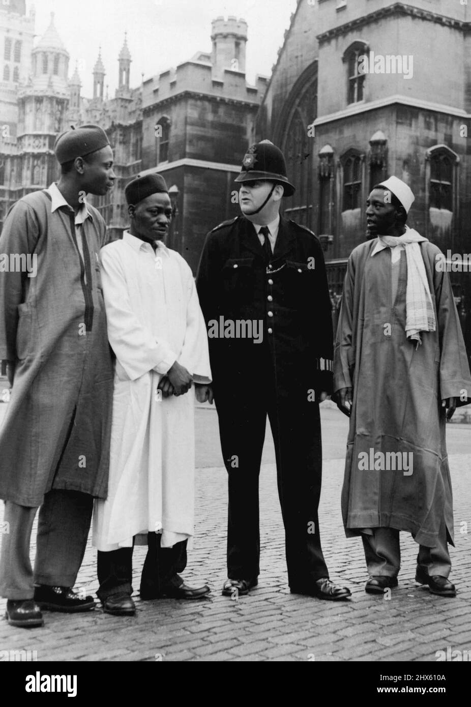 African Visitors In London -- Left to right:- Sani Ahmed, Sulymann Bomai, Shehu Maska, the last two come from ia, seen talking to a Policeman outside the Houses of Parliament this morning. Eight Ugandan Chief and nine Northern ian administrators who are visiting the United Kingdom for six weeks, under arrangements made by the British Council at the request of their governments, are visiting places of interest in London during the next 10 days. September 30, 1955. (Photo by Fox Photos). Stock Photo