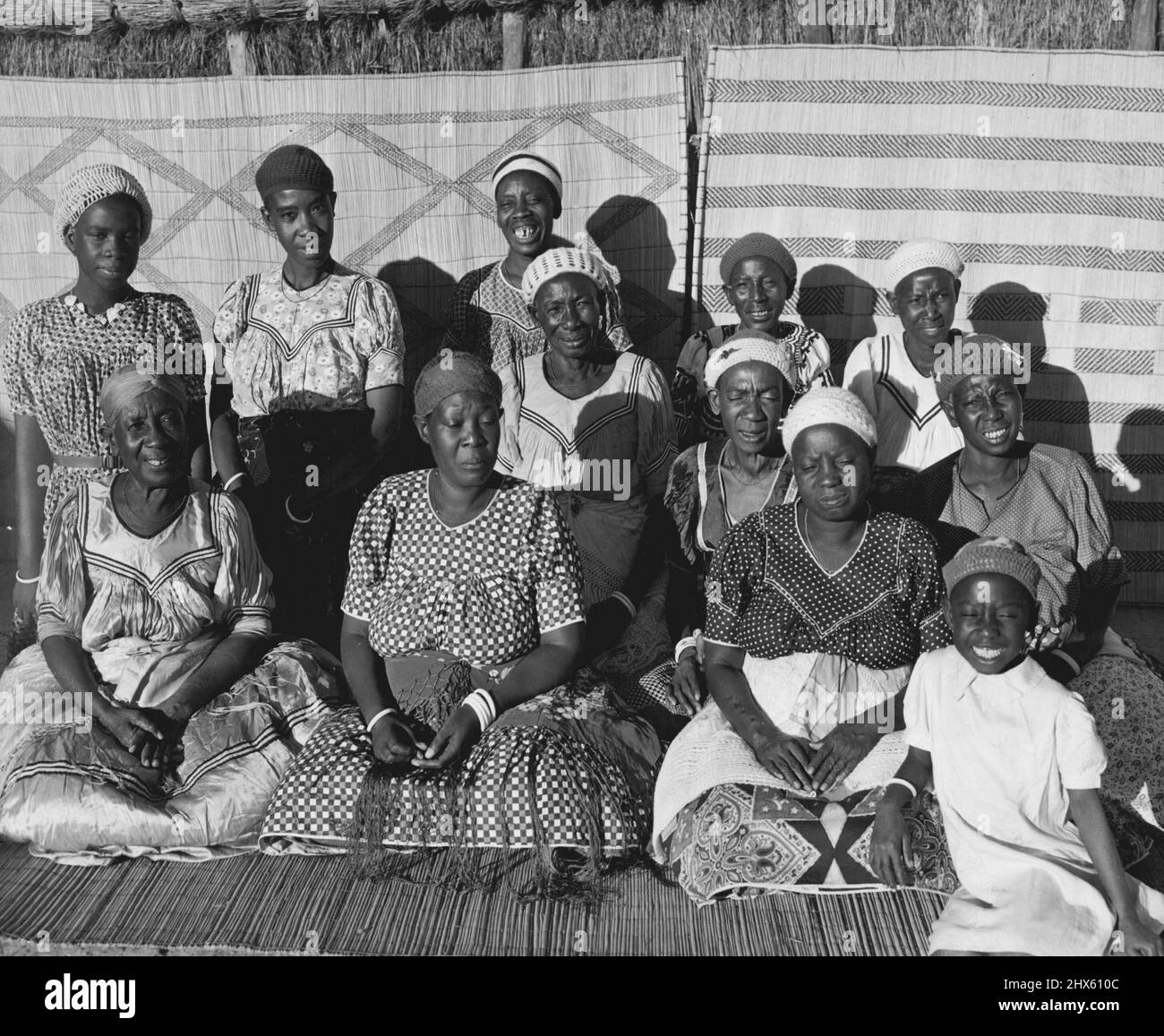 Barotse Women -- A group of the Paramount Chief's family in their traditional dress. In the front row on the left is the Chief's aunt wearing a dress of fine silk that has been her proud possession for almost fifty years. On the right is the Chief's grandchild. June 23, 1952. (Photo by Nigel Watt, Camera Press).;Barotse Women -- A group of the Paramount Chief's family in their traditional dress. In the front row on the left is the Chief's aunt wearing a dress of fine silk that has been her proud Stock Photo