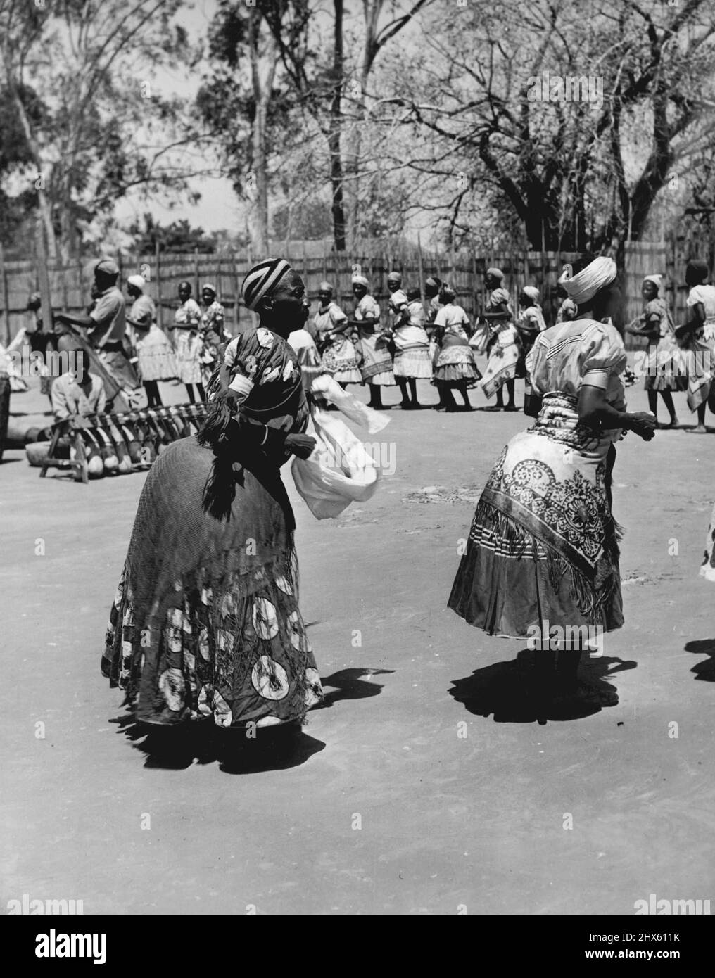 Barotse Women -- Women of the Barotse Chief's Court perform the Dance of Welcome, called the 'Limba'. It is a peculiar shuffling kind of dance to a rhythm provided by the Africa xylophone (Silimba) and drums made from gourds. It goes on for hours. In the foreground are two fine examples of the Court dress worn by the Barotse women. This was the dance that intrigued the former Secretary of State for the Colonies Mr. James Griffiths, on his recent visit to Barotseland. June 23, 1952. (Photo by Nig Stock Photo