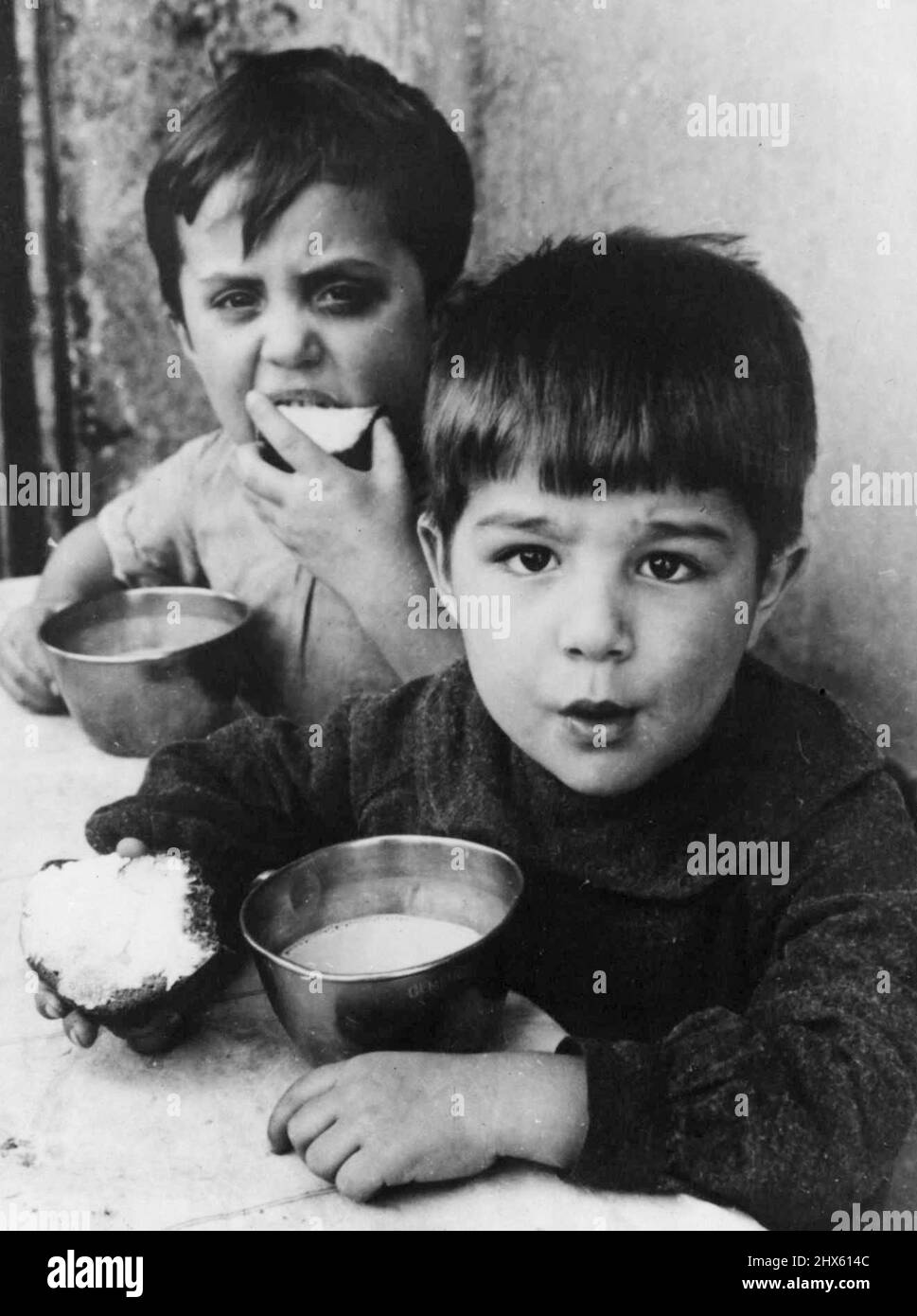Their Daily Bread-From UNICEF -- These are Austrian boys. They could be Italian, Rumanian, Czechoslovakian Greek. They could be children in any of the 12 European Countries which are receiving daily supplementary meals from the United Nations International children's emergency fund (UNICEF). Today UNICEF is providing milk, fats, and meats to almost 4,500,000 European children and nursing and pregnant women. Most of the children, like these boys, receive a cup of mild, lard for their bread and v Stock Photo