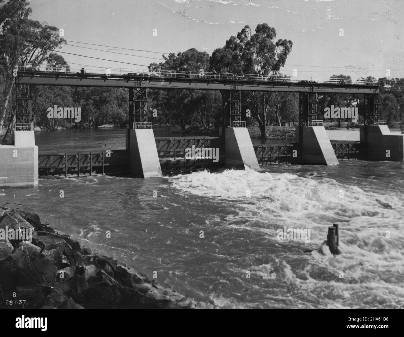 Irrigation -- Loan funds are required for the extension of irrigation. This photograph shows Stevens Weir on the Edward River. This weir diverts water to the Wakool Irrigation District. Other lands now being developed for food production require life giving water. The 17th Security Loan aims to provide the funds necessary to bring water to the parched outback. Rainwater in great coastal catchment dams like the Warragamba, Avon and Nepean could be diverted inland to help open up new country to c Stock Photo