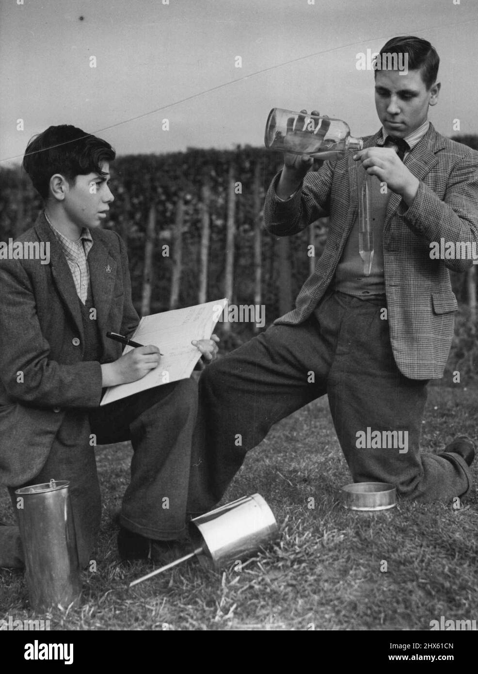 Boys Run An Official Met. Station. -- Two youngsters at the school, David White and Sidney Kurton, taking the daily rainfall measurement. A class of boys at the Piggott Secondary Modern Church of England school, Wargrave, Berks, has been recognised by the Air Ministry as official Rainfall station No. 782/2/1. Station 782/2/1 is run entirely by the boys, whose average age is only fourteen, with only superficial supervision now from the teachers, who have encouraged them to do a man's job while le Stock Photo