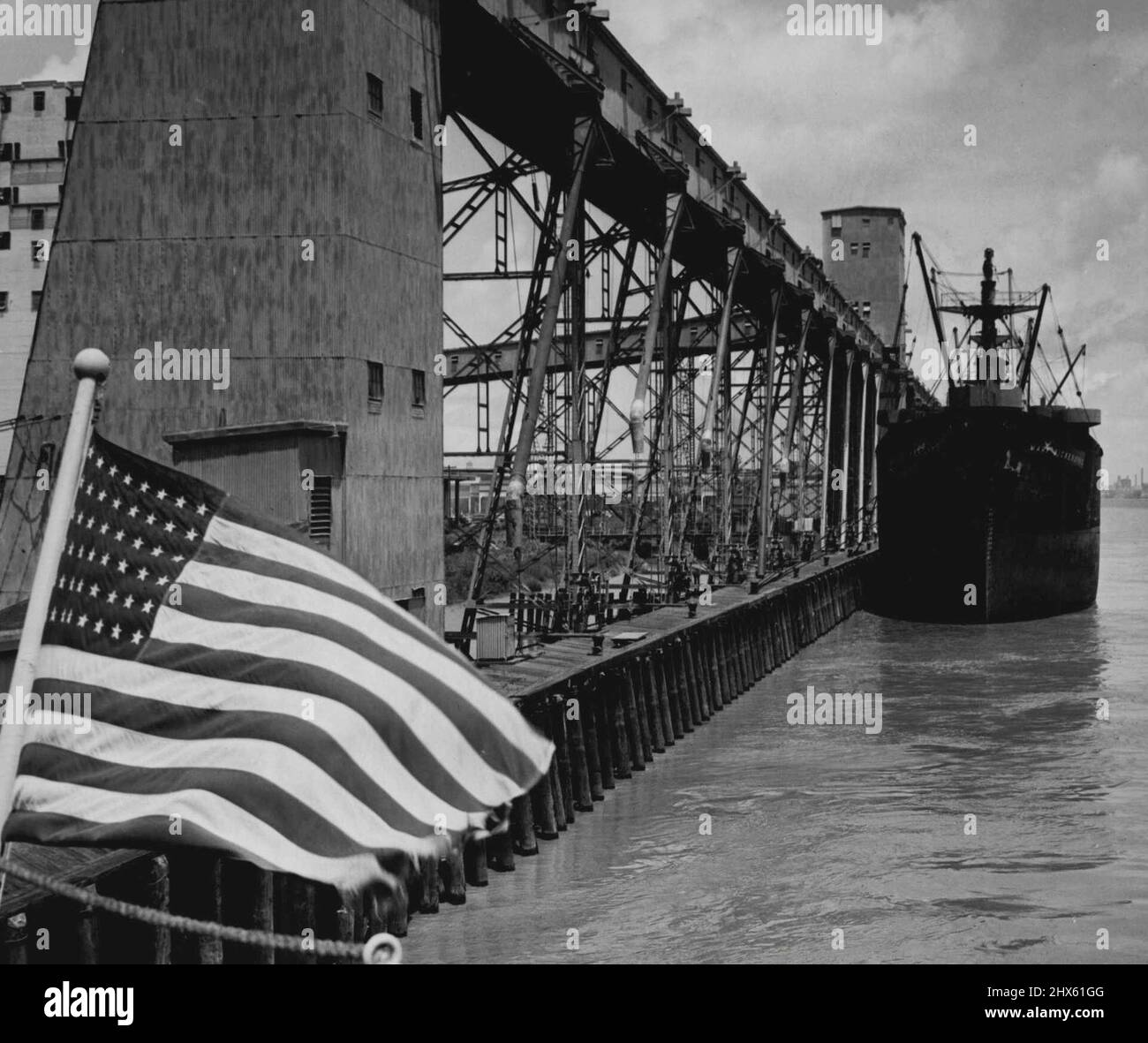 Awaiting Full Cargo -- Tied to pier beside the grain elevator at New Orleans, La., a foreign bound ship waits for full cargo to be placed aboard. Grain in shipped to all parts of the world from this port as the United States helps to feed the starving peoples of allied as well as defeated nations. June 16, 1946. (Photo by Associated Press Photo).;Awaiting Full Cargo -- Tied to pier beside the grain elevator at New Orleans, La., a foreign bound ship waits for full cargo to be placed aboard. Grain Stock Photo