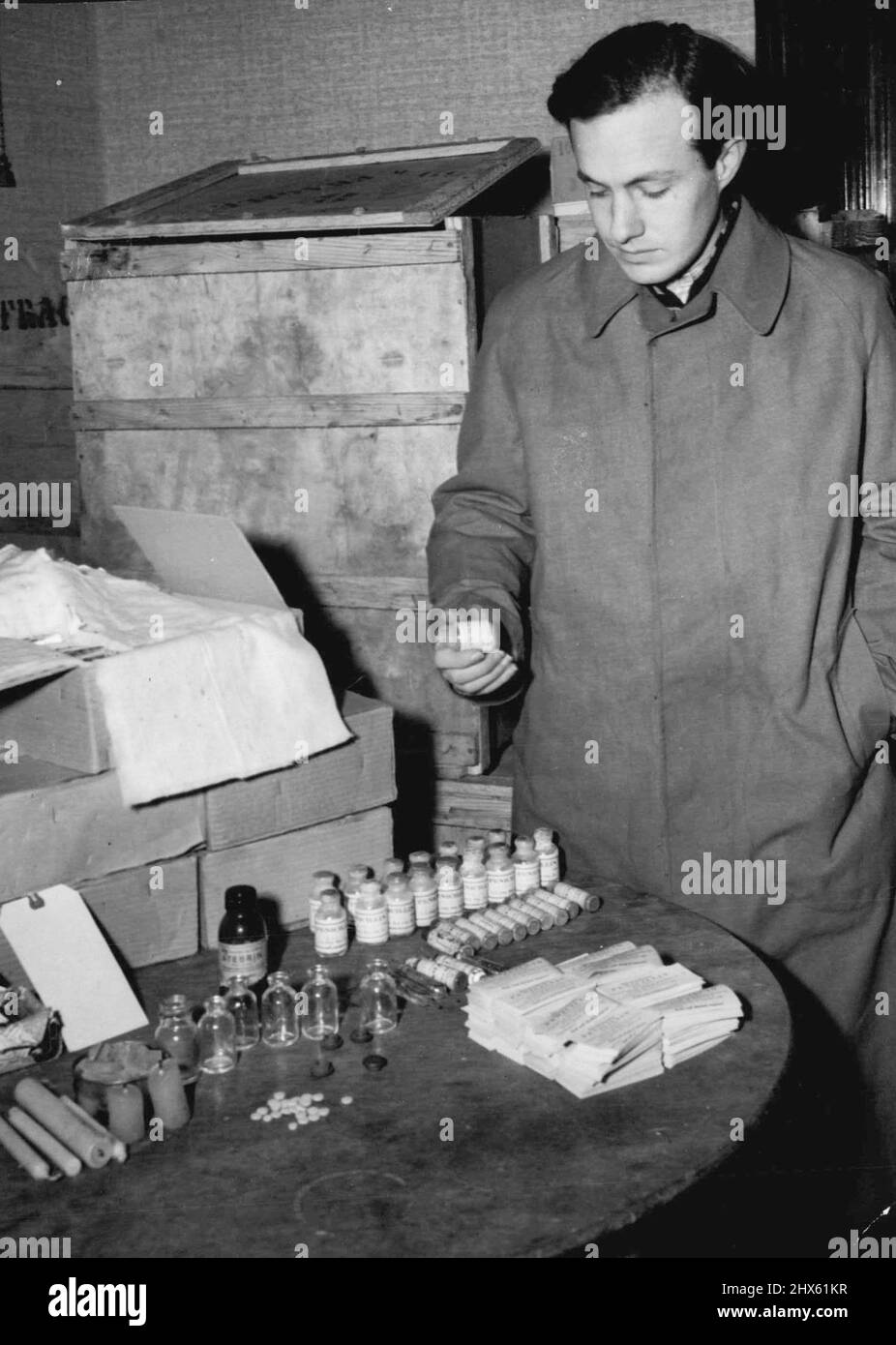 Allied Police Round Up Fake Penicillin -- Peter Domke, charged with being the chief of the fake drug ring stands beside a table littered with chemicals used in the manufacture of fake penicillin. Over a million dollars worth of fake drugs including penicillin have been discovered by Allies police in Berlin American and British CID men arrested seven men and three women on charges manufacturing and selling fake penicillin. It was stated that some of the fake drugs had been administered to a Russi Stock Photo