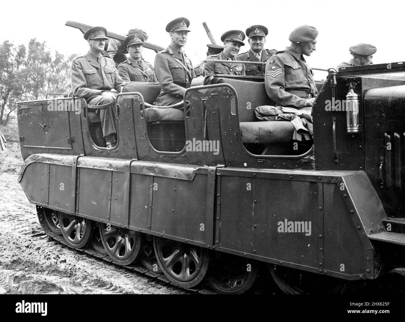 The King Rides In German Half-Track Vehicle -- His Majesty king George VI travel in a German Half-Track Vehicle (seated at left of center seat) during his visit to the Army Cadet Force camp at Aldershot, Hants., August 3. The king toured the camp in this Vehicle. August 4, 1948. (Photo by Associated Press Photo) ;The King Rides In German Half-Track Vehicle -- His Majesty king George VI travel in a German Half-Track Vehicle (seated at left of center seat) during his visit to the Army Cadet Force Stock Photo