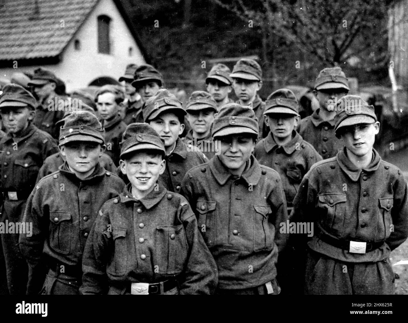 German Boy Soldiers Captured by 11th., Division -- A group of the youngsters in their uniforms. The Americans sent them back to their parents, instead of to a prison camp. When the 11th., Armoured division advanced into the area, of Kronach, they found that all the boys of 15 and get on the road to Bavaria. They were taken by their 22-years-old leader into the woods and there waited the arrival of the Americans to whom they gave themselves up. April 25, 1945.;German Boy Soldiers Captured by 11th Stock Photo