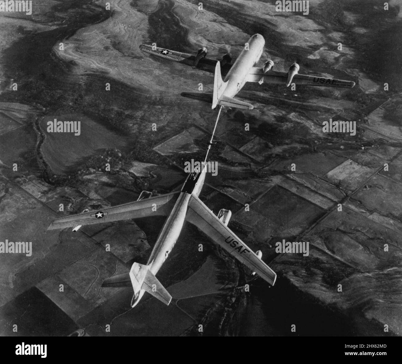 Fastest Jet Bomber Tanked Up In Air -- Here's the first released picture of the world's fastest bombers, a six-jet, 600-mile an-hour Boeing B-47 stratojet bomber, (bottom) being refueled from a double-deck Boeing KC-97A tanker plane. In this method of refueling, now a standard U.S. Air Force practice, fuel boom form under tail of tanker plane is connected with coupling in nose of bomber and the fuel is pumped in at high speed. June 18, 1951. (Photo by AP Wirephoto). Stock Photo