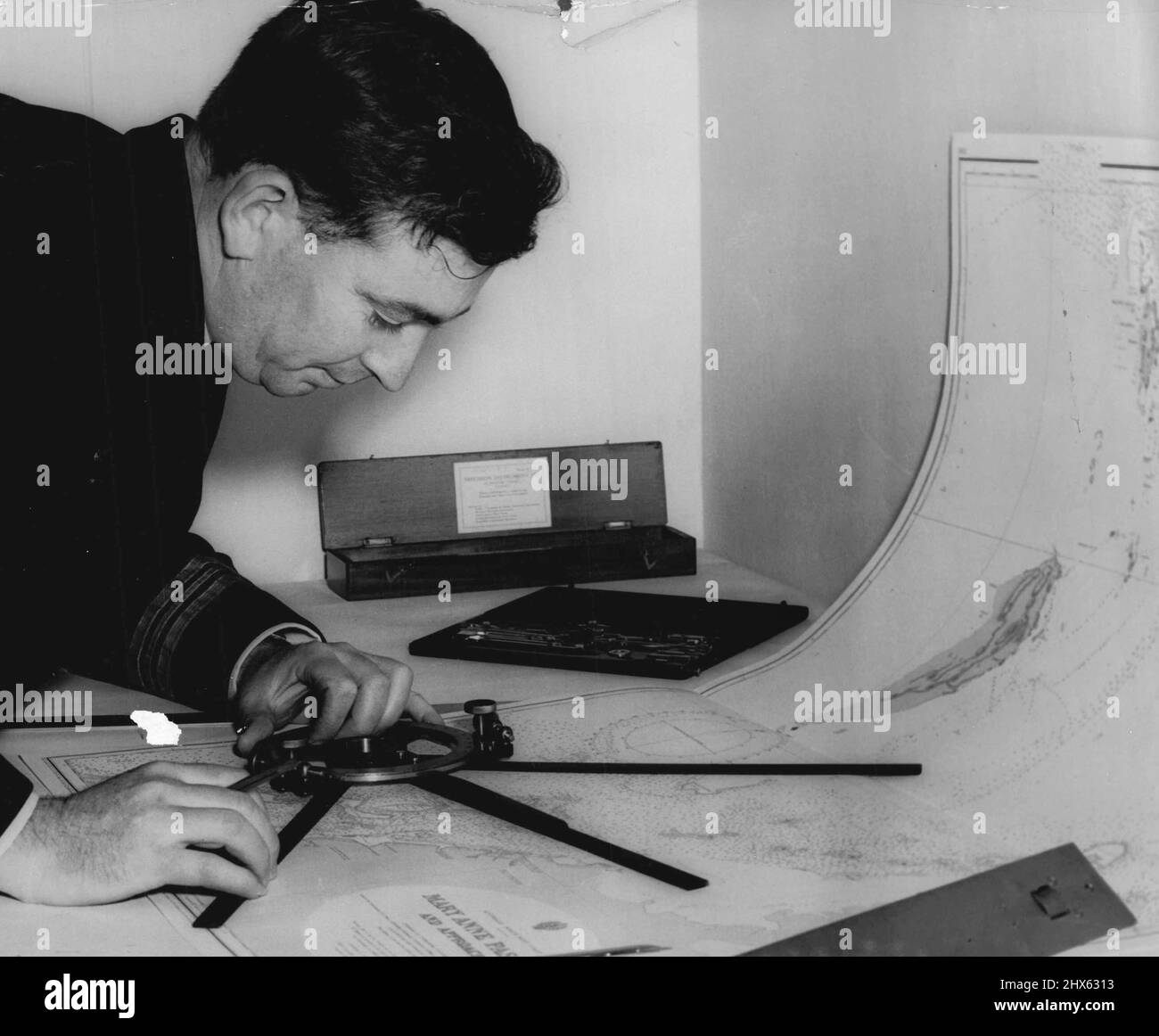 Not To Be Heed Until News Announced -- Not Commander R. J. Hardstaff, deputy senior officer Ran Hydrographic service and superintendent of the chart depot, checking a chart for HMAS warrego which is leaving to carry out survey duties in the monte bello area in connection with the projected atom bomb explosion. September 15, 1955. (Photo by Ronald Leslie Stewart/Fairfax Media). Stock Photo