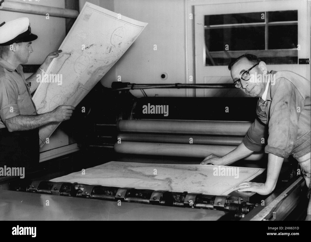 First Exmouth Gulf Charts -- The Ran Hydrographic printing office as garden is at present producing the first exmouth gulf charts to be available to the public. They will be issued as from Monday next. On right is Mr. J. H. Tepper, Lithographic printer who is printing the charts and left is petty officer W.R.Wallace, A Survey recorder who took part in the survey carried out by HMAS Barcoo. September 15, 1955. (Photo by Ronald Leslie Stewart/Fairfax Media). Stock Photo