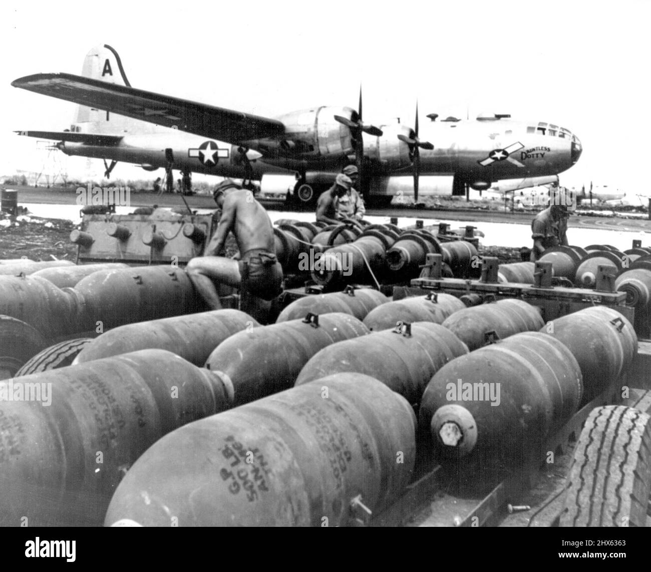 Saipan Superforts Prepared For Tokyo Attack Ground, crewmen prepare bombs for loading into a 3-29 Superfortress, the 'Dauntless Dotty' at the new American air base on Saipan Island in the Marianas. The plane led the first Superfortress attack on Tokyo on Nov.23, 1944, giving the Japanese capital its first taste of American explosives in more than two and one half years. The bombers set aflame key industrial centers, including the Musashino airplane plant, long a cherished target; and met little Stock Photo