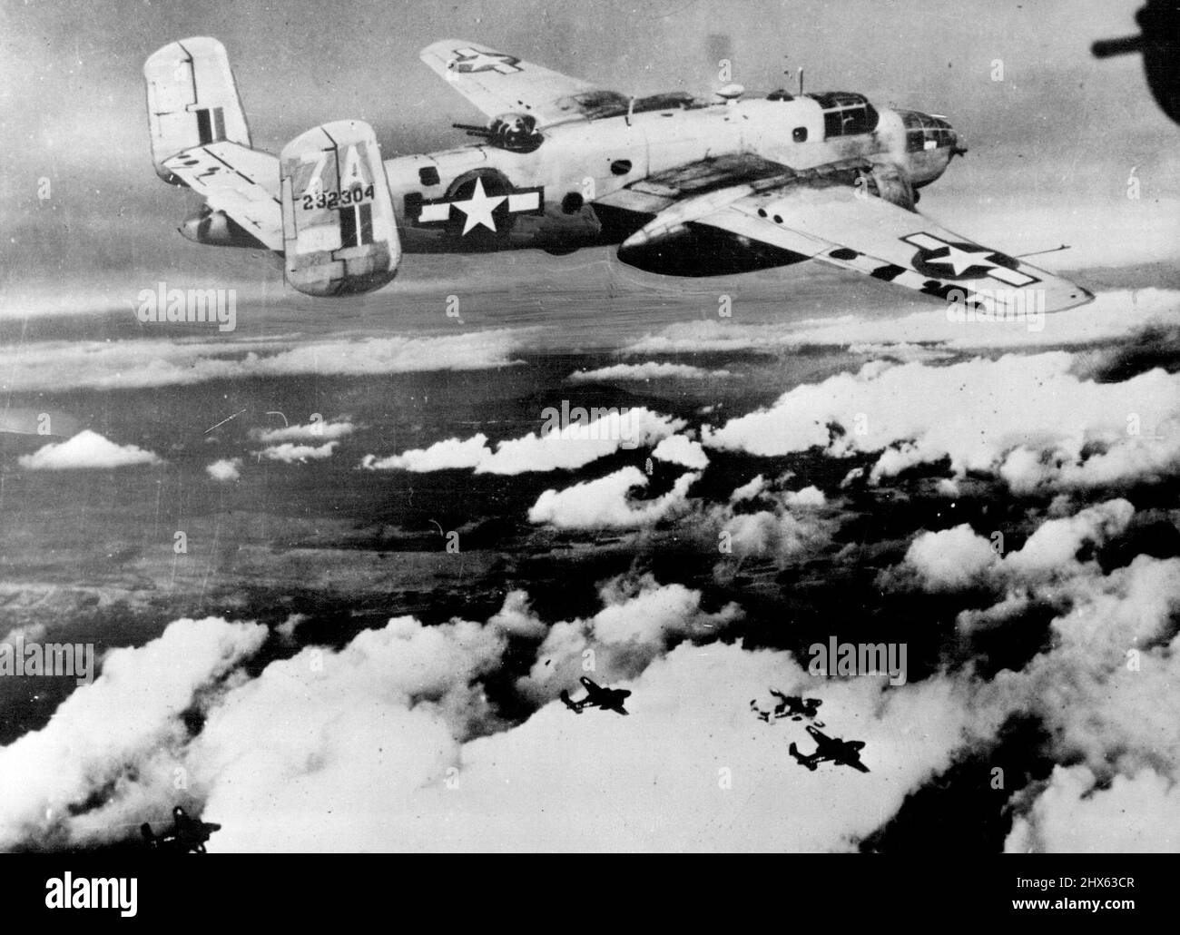 U.S. Bombers Blast German Installations In Yugoslavia. Soaring high above scattered clouds, a squadron of B-25 Mitchell medium bombers of the Twelfth U.S. Amy Air Force blasts the port of Sibenik, Yugoslavia, damaging the German-held airfield, railway yards and supply depots. Raids by Allied pianos over German supply bases and communication lines are helping Yugoslav patriots in their fight against the invader. February 14, 1944. Stock Photo