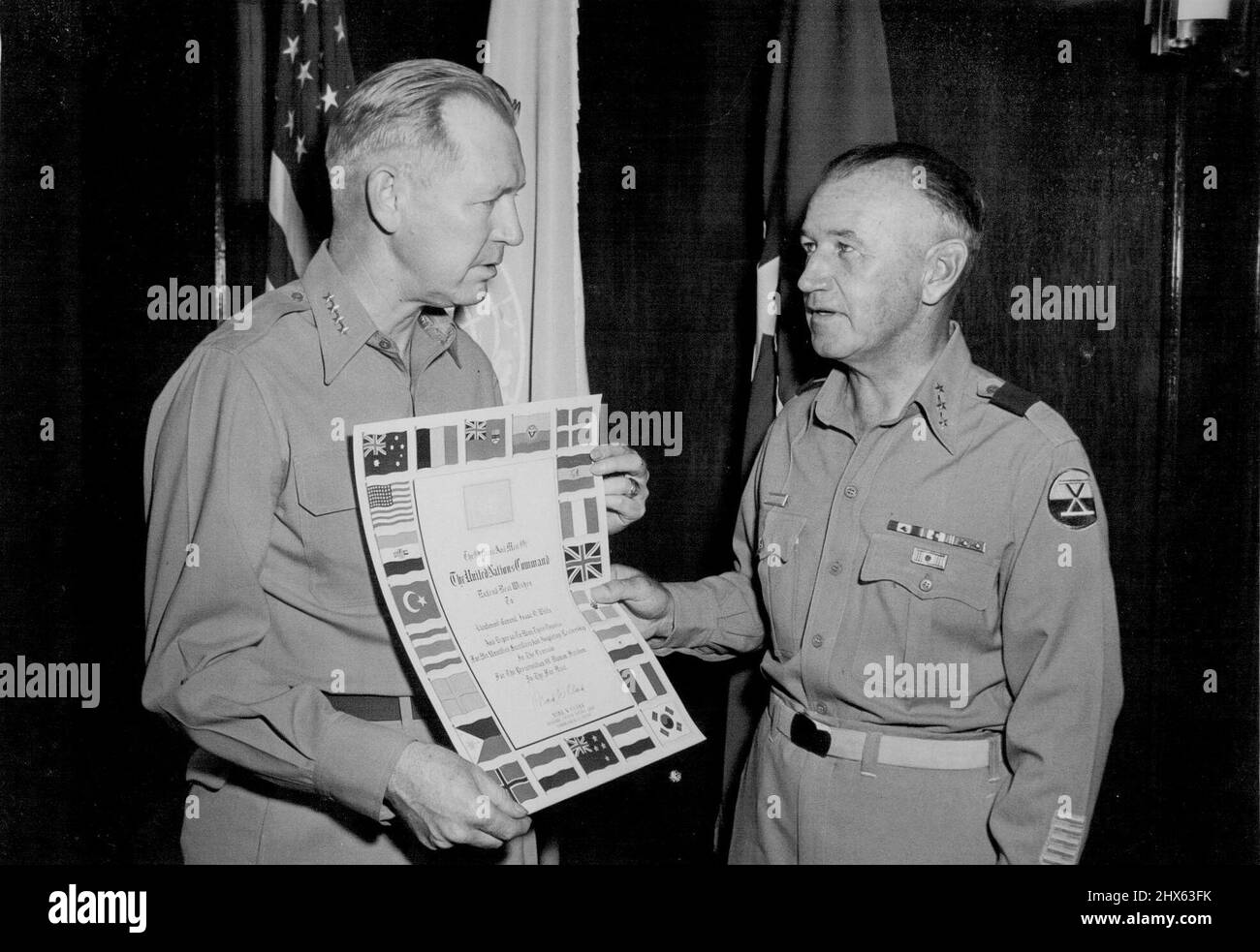 Lt. Gen. Issac D. White (right) former CC, X US Corps, is presented the United Nations plague by general Otto P. Weyland, acting cinofe and CG, Feaf, during ceremony at ***** Tokyo, Japan. Lt. Gen. White ***** to the United States for his ***** as CG, second Army. August 14, 1953. (Photo by Sgt. Robert S. Leonard, US Army Photograph). Stock Photo