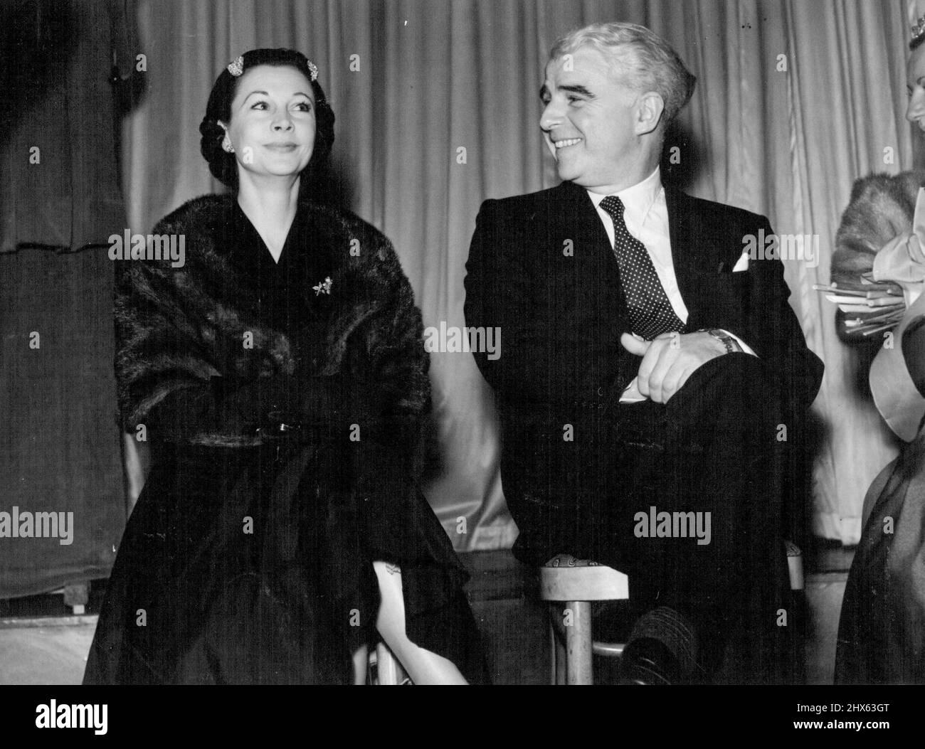 Party For The Names-In-Neon -- Seen talking together at the party, actor Emlyn Williams and Lady Olivier (actress Vivien Leigh). A big theatrical party was held in London, last night, by actor Emlyn Williams. Actress Vivien Leigh unveiled a plaque that will be the cover of the Souvenir brochure for the Midnight Cavalcade Gala, to be held at the London Palladium on March 18. It was designed by Cecil Beaton. The gala is in aid of the Actors Orphanage and Grand Order of Water Rats and the Jewish Na Stock Photo