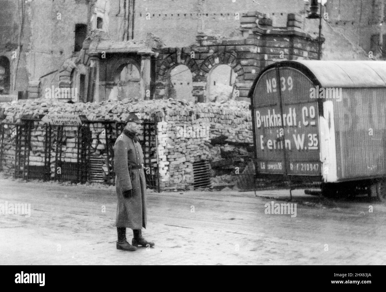 One of a Set: Germans man barricades in Berlin a German policeman patrols the entrance ***** one of the barricades that were erected ***** Berlin prior to the fall of the city. The bins are filled with bricks, while the ***** body is loaded with stones, ready to be ***** across the opening of the barricade. July 31, 1945. (Photo by Associated Press Photo). Stock Photo