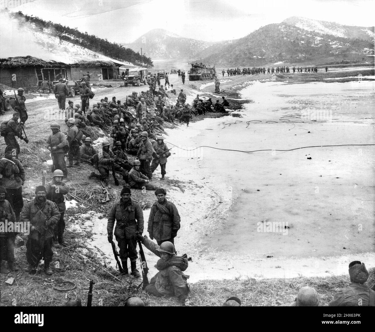 A Day With The 25th (Ninth of Ten) - Turkish troops (background) move up to the front while other turks (foreground) await their turn to relieve American 25th division troops North of Anyang. February 3, 1951. (Photo by ACME). Stock Photo