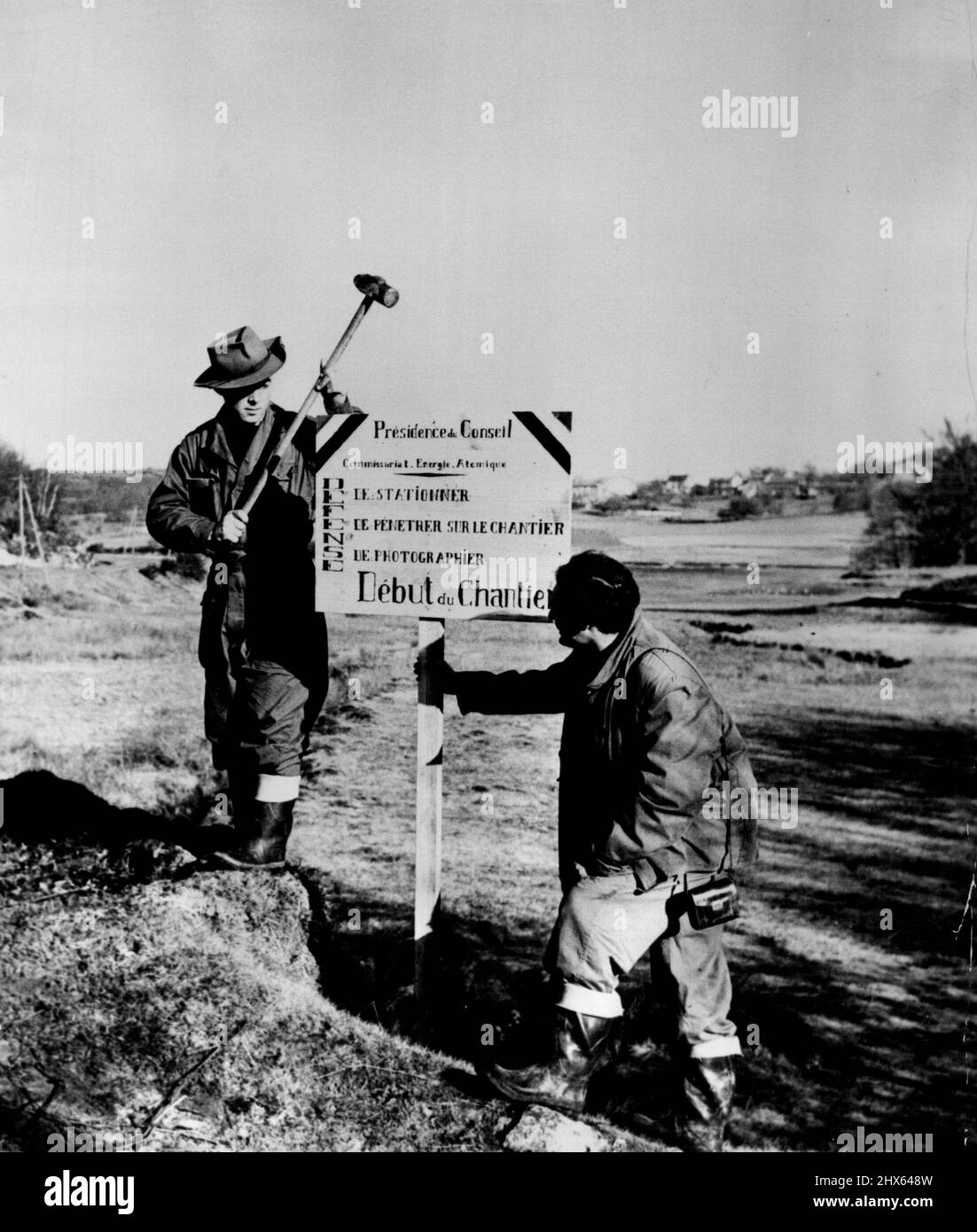 Uranium Strike - Two of the young prospectors post a sign at the boundary of the French uranium diggings. By authority of the French Atomic Energy Commission, the notice for bids entry, loitering and photography of the area. March 18, 1949. (Photo by ACME Roto Service). Stock Photo