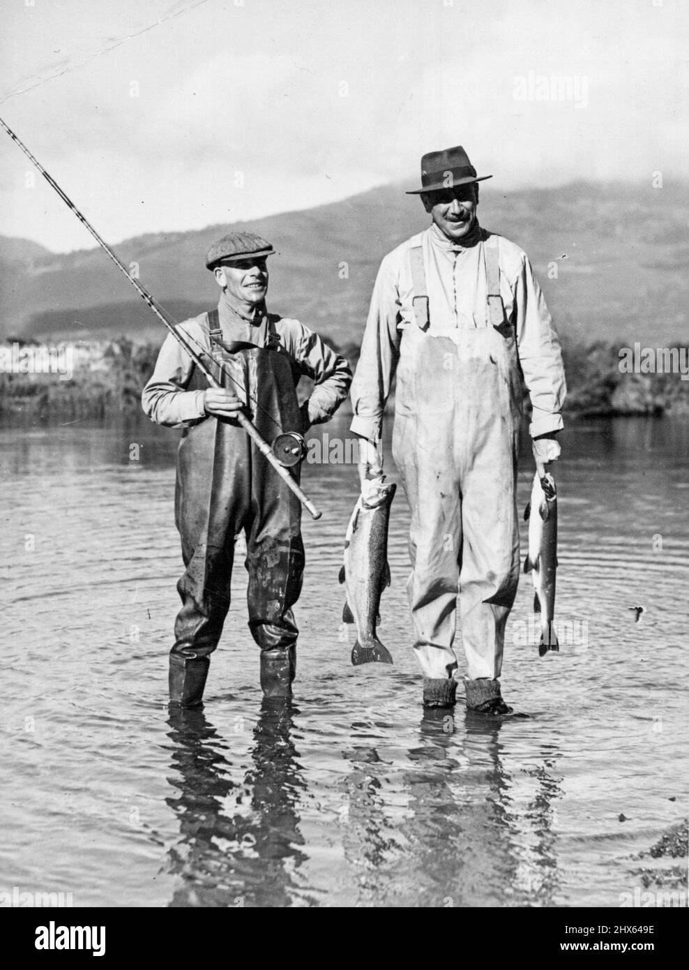 New Zealand's trout fishing second to none. The Governor - General of New Zealand, Viscount Galway, with his gillie a at Tongariro river pool , in the Lake Taupo district. July 04, 1938. Stock Photo