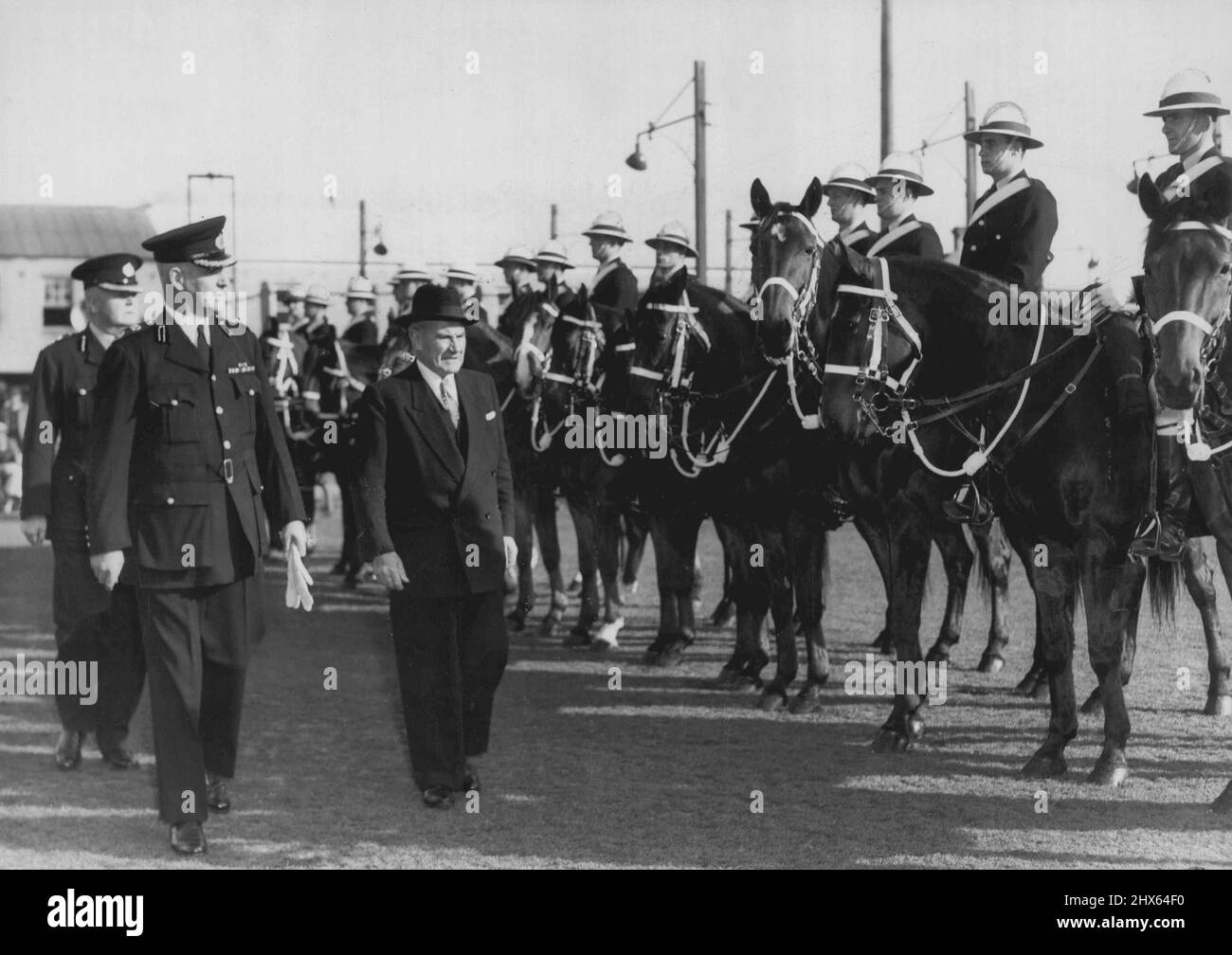 Police Passing out Parade -- The Premier, Mr. J.J. Cahill (right) Inspecting a guard of honour of Mounted Police with the Deputy Police Commissioner Mr. G. L. Smith. 76 trainee police constables passed out in ceremony at the police training center Redfee today. July 18, 1955. (Photo by George Lipman/Fairfax Media). Stock Photo