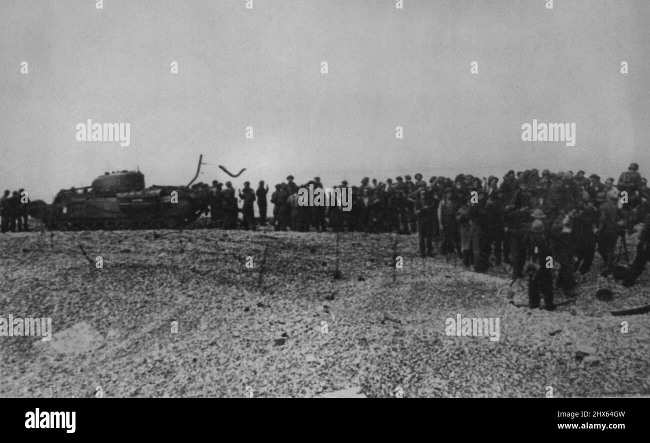 The Aftermath of Dieppe - New Pictures Captured Commandos are led off the beach past the bulk of a disabled tank. September 9, 1942. (Photo by Associated Press Photo). Stock Photo