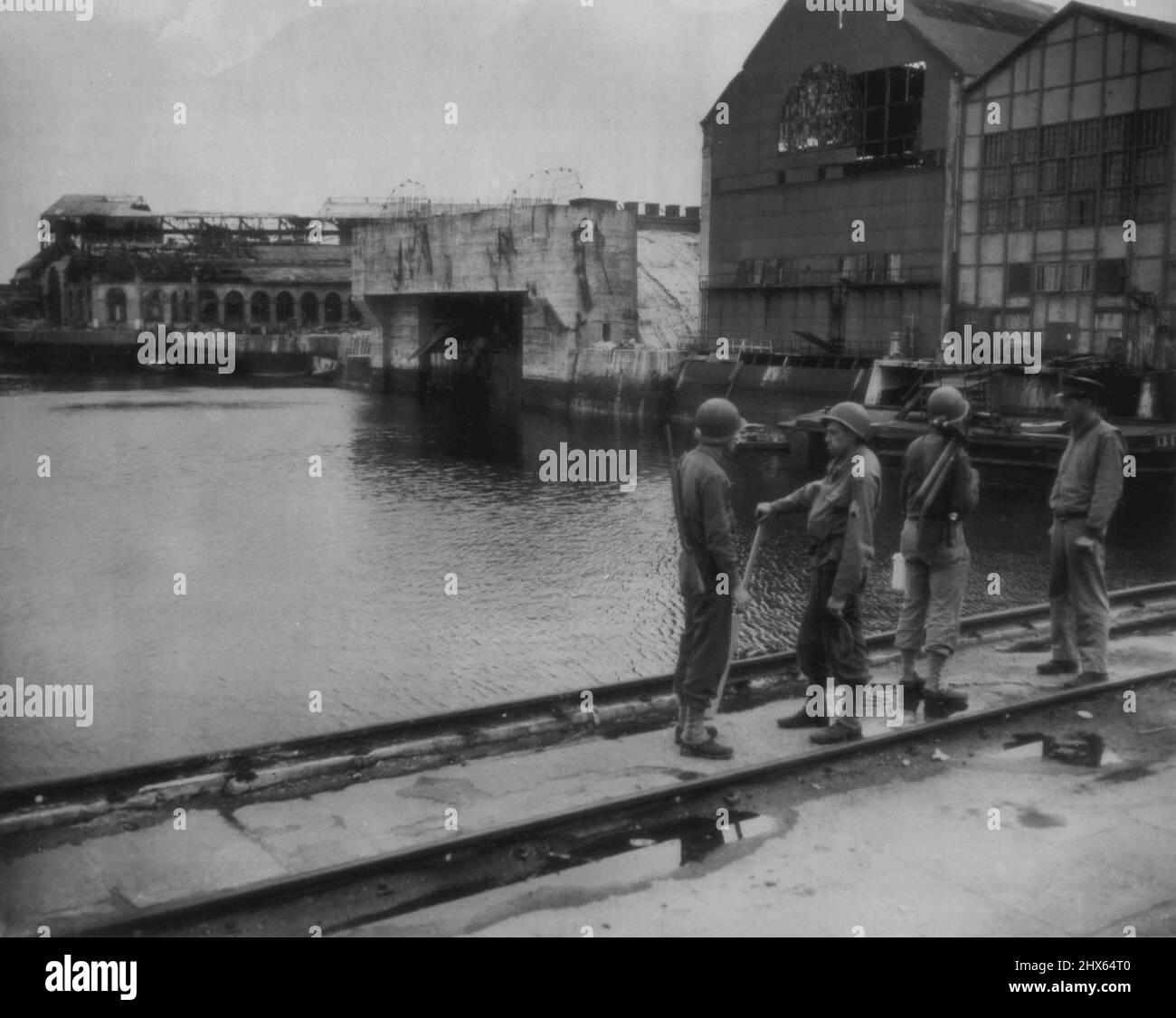 An 'E' Boat Pen at Cherbourg -- A German 'E' boat pen shown in the center of this view of part of the docks in the harbor of Cherbourg, France, now under repair by Allied engineers. August 28, 1944. Stock Photo