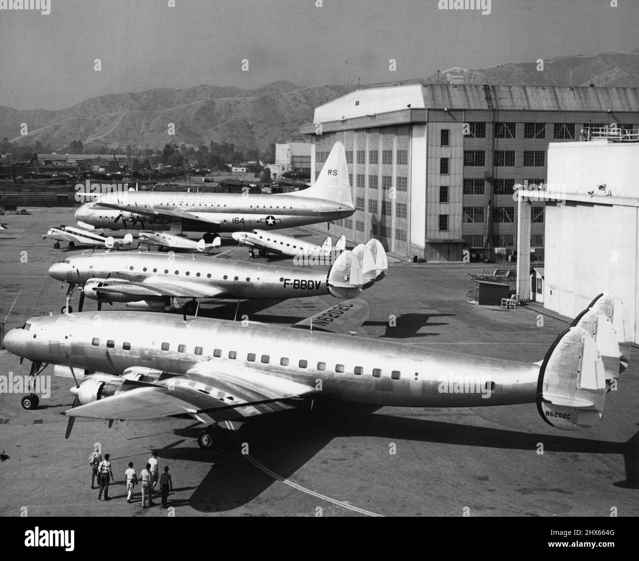 And Still They Grow -- How transport aircraft have grown in 18 years is illustrated in this 'family portrait' released by Lockheed Aircraft Corporation today showing six models, ranging from old to new, of principal Lockheed airlines when all were in reunion at their home airport at Burbank, Calif. Since days of 1934 Electra, 1937 Model 14 and 1939 Lodestar (small planes, left to right), capacities have increased from 12 passengers to about 50 to 100 in modern Constellation types (two front ship Stock Photo