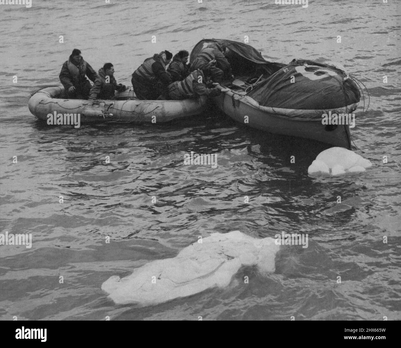 Rescue By Airborne Lifeboat -- ***** rescued by airborne lifeboat ***** their dinghy to lifeboat. Rescue from the sea by lifeboat dropped from aircraft is now a ***** of the work of R.A.F. Coastal ***** Sea Rescue Service. Lifeboats, fitted ***** 4.h.p., two-stroke engines, contain ***** needed by men suffering from ***** exposure, such as warm waterproof clothing ***** and medical supplies, which are dropped from ***** of 700 feet, suspended by air parachute ***** first rescue by airborne lifeb Stock Photo