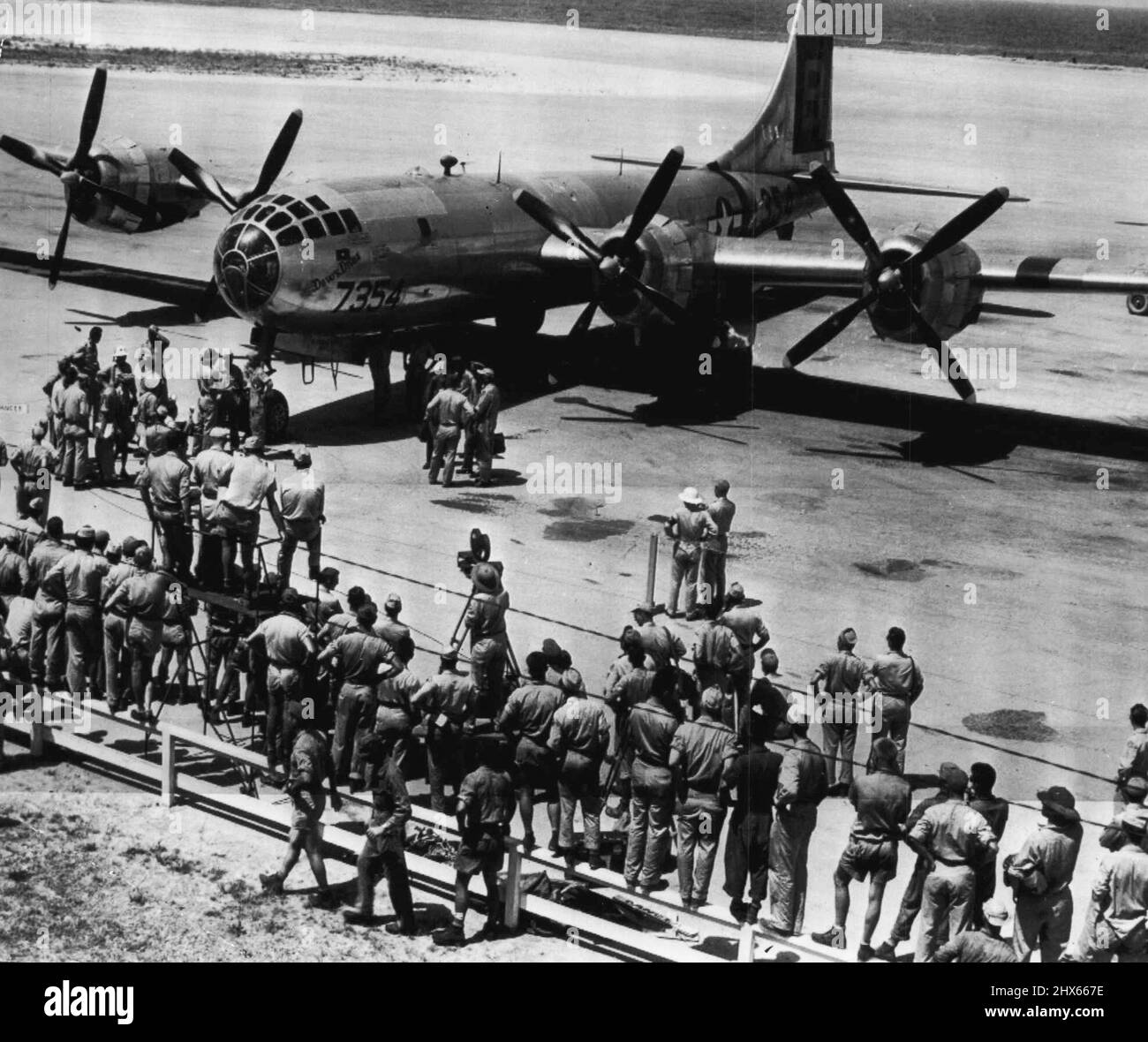 Atomic Bombing Plane Returns To Base After Blast -- Base personnel welcomes the B-29, 'Dave's Dream,' as it returns to the field at Kwajalein July 1 after dropping an atomic Bomb over a 'sitting duck' naval fleet at Bikini during joint U.S. Army-Navy test. No Identification of persons in picture is available. This is third original, picture on bomb test released it Washington. July 4, 1946. (Photo by AP Wirephoto). Stock Photo