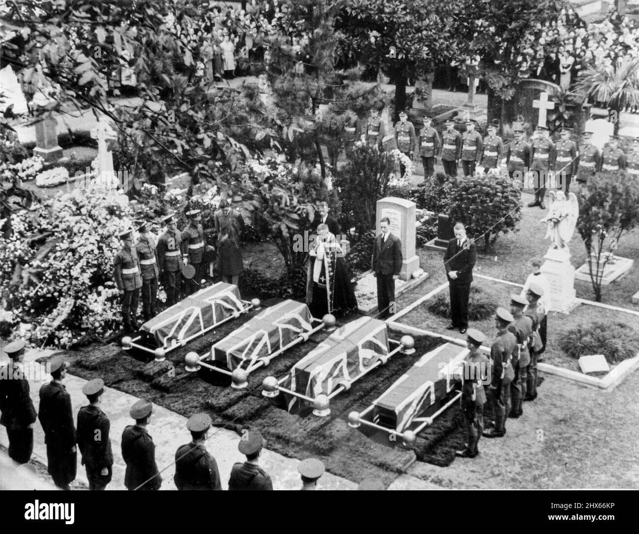 Graveside Services For British Soldiers -- A minister reads the last rites just before the four coffins of members of the Ulster Rifles, British regiment on defense duty in Shanghai, were lowered November 1. The four men were killed by Japanese artillery fire. November 19, 1937. (Photo by Associated Press Photo). Stock Photo