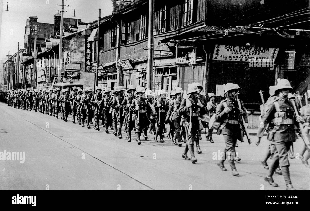 Welch Fusiliers Leave Shanghai -- The Welch Fusiliers marching into Hongkew which is virtually Japanese controlled now. The Welch Fusiliers, who have done splendid work in protecting British residents and interests in Shanghai during the war, have now left the city for Hong Kong on the troopship Dunera. A large crowd of onlookers watched the spectacle of the first Foreign troops crossing into Hongkew since the start of the hostilites. Japanese Marines on guard at the bridge stood smartly to atte Stock Photo
