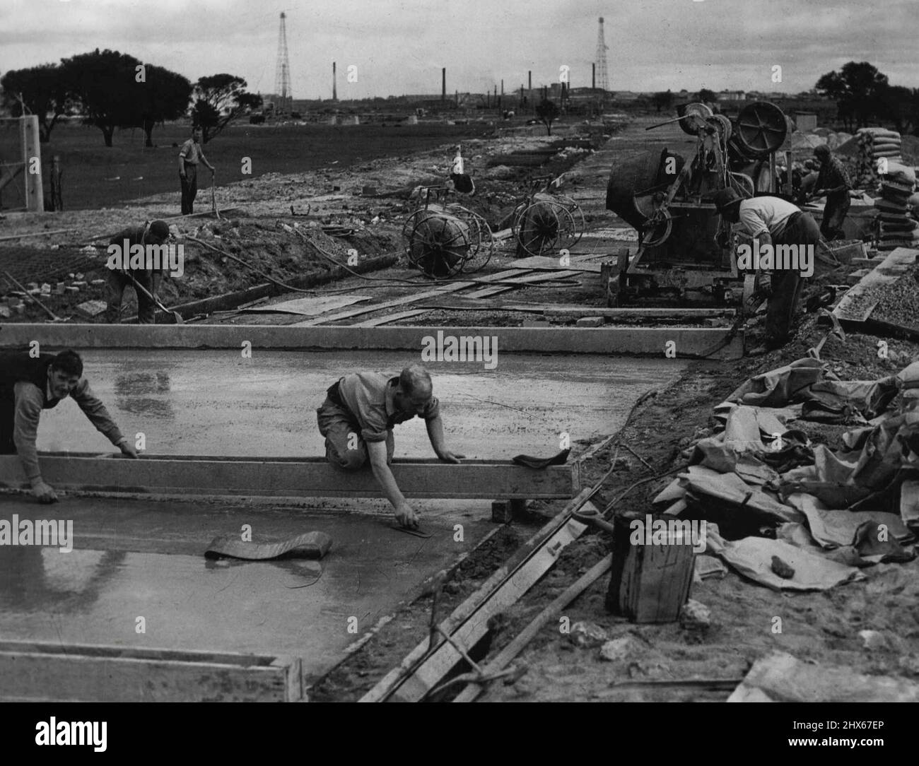 Soon To Start Production - Production at the new Commonwealth Aircraft Corporation factory at Fisherman's Bend, Melbourne, will soon start. To make easier access to the factory, a concrete road a mile long, is being laid down. Men are shown at work on the road. September 14, 1937. Stock Photo
