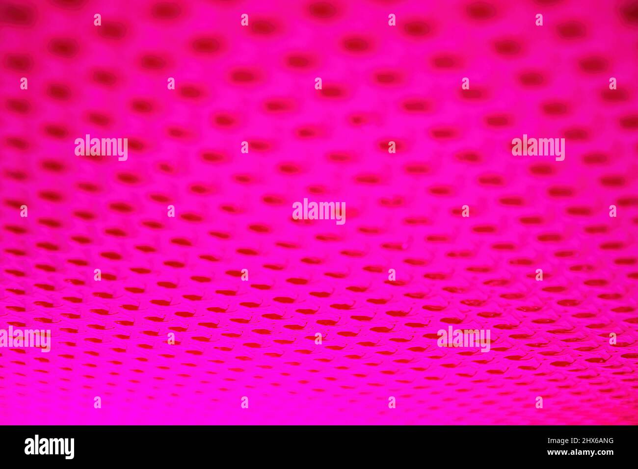 Abstract surface with holes highlighted by pink neon led lights. Abstract backgrounds and textures Stock Photo