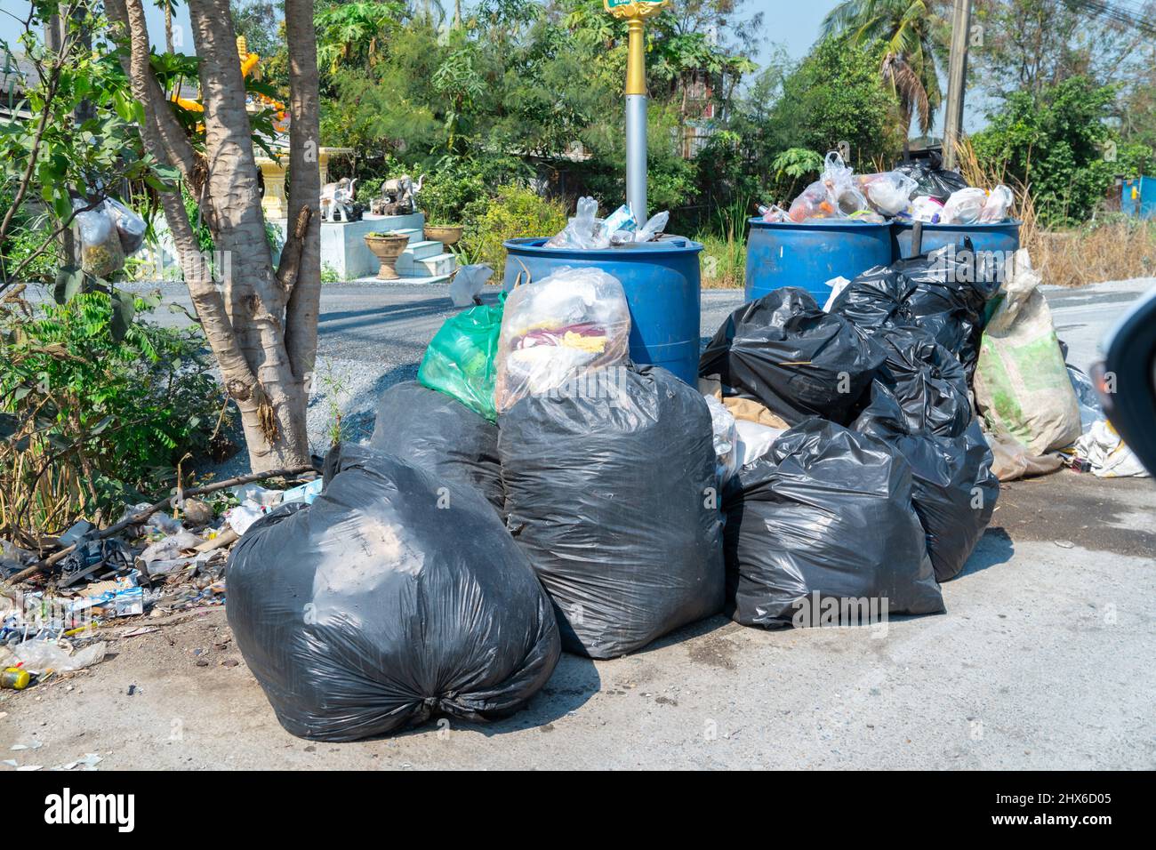 Black plastic trash bin bags of garbage on the pavement, clean