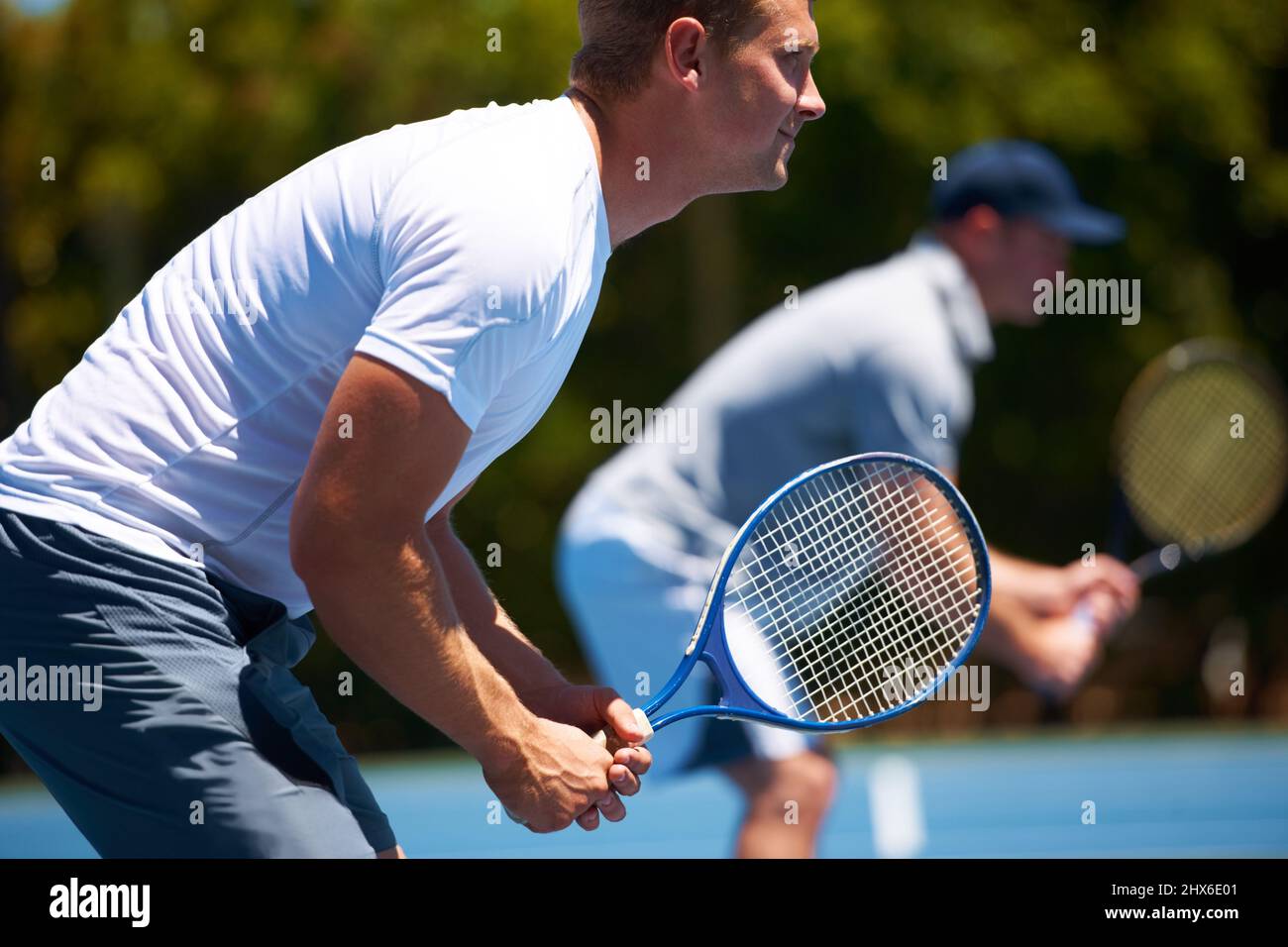 Team tennis. Shot of two men playing a tennis match on a sunny day. Stock Photo